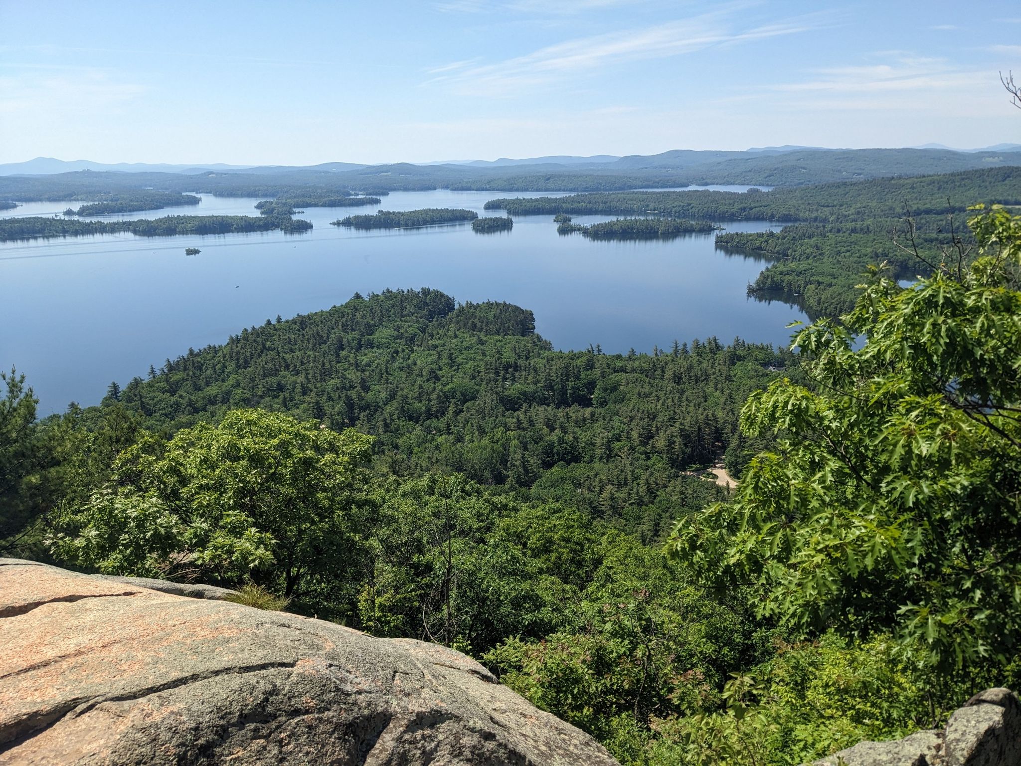 Sunny panoramic view of a large lake with many islands and green forests. - West and East Rattlesnake Mountain via Old Bridle Path