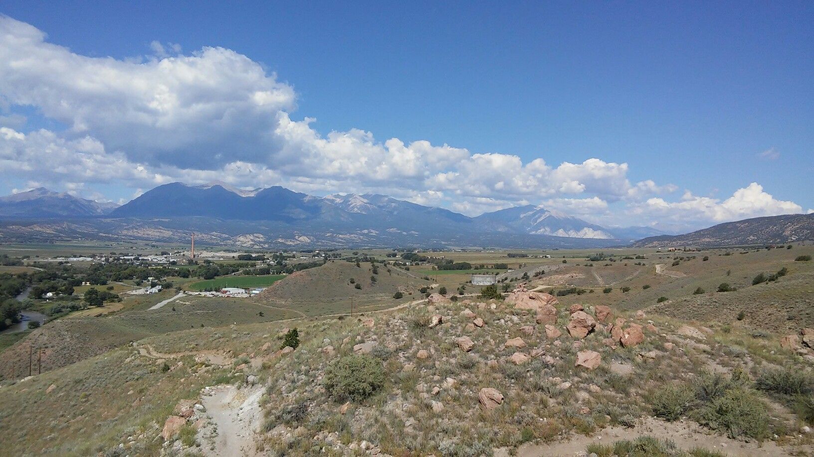 Expansive landscape with rocky hills, a green valley, and distant mountains. - Sweet Dreams and Chicken Dinner Loop