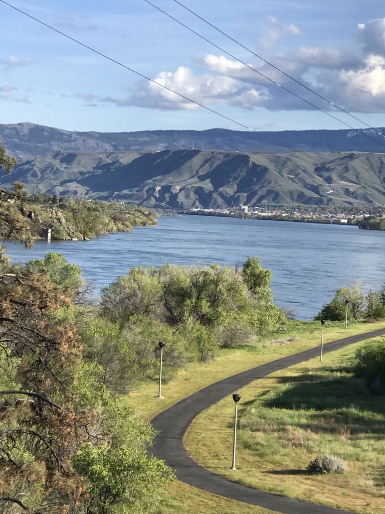 Winding paved path overlooking a wide river and distant mountains, sunny. - Riverfront Park – Walla Walla Point Park loop from Wenatchee