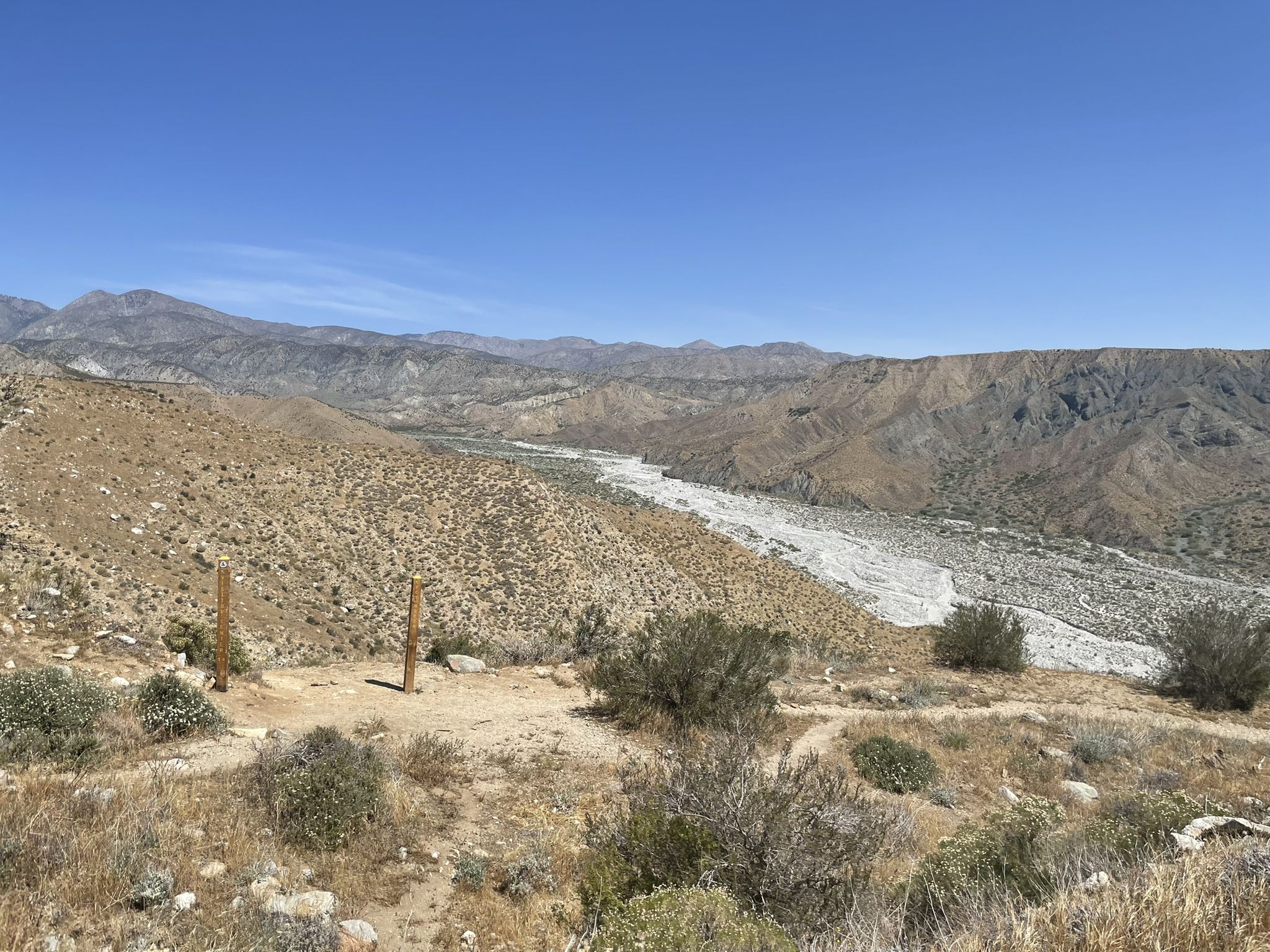 Panoramic view of a wide, dry riverbed winding through arid mountains. - Whitewater Canyon View Loop Trail