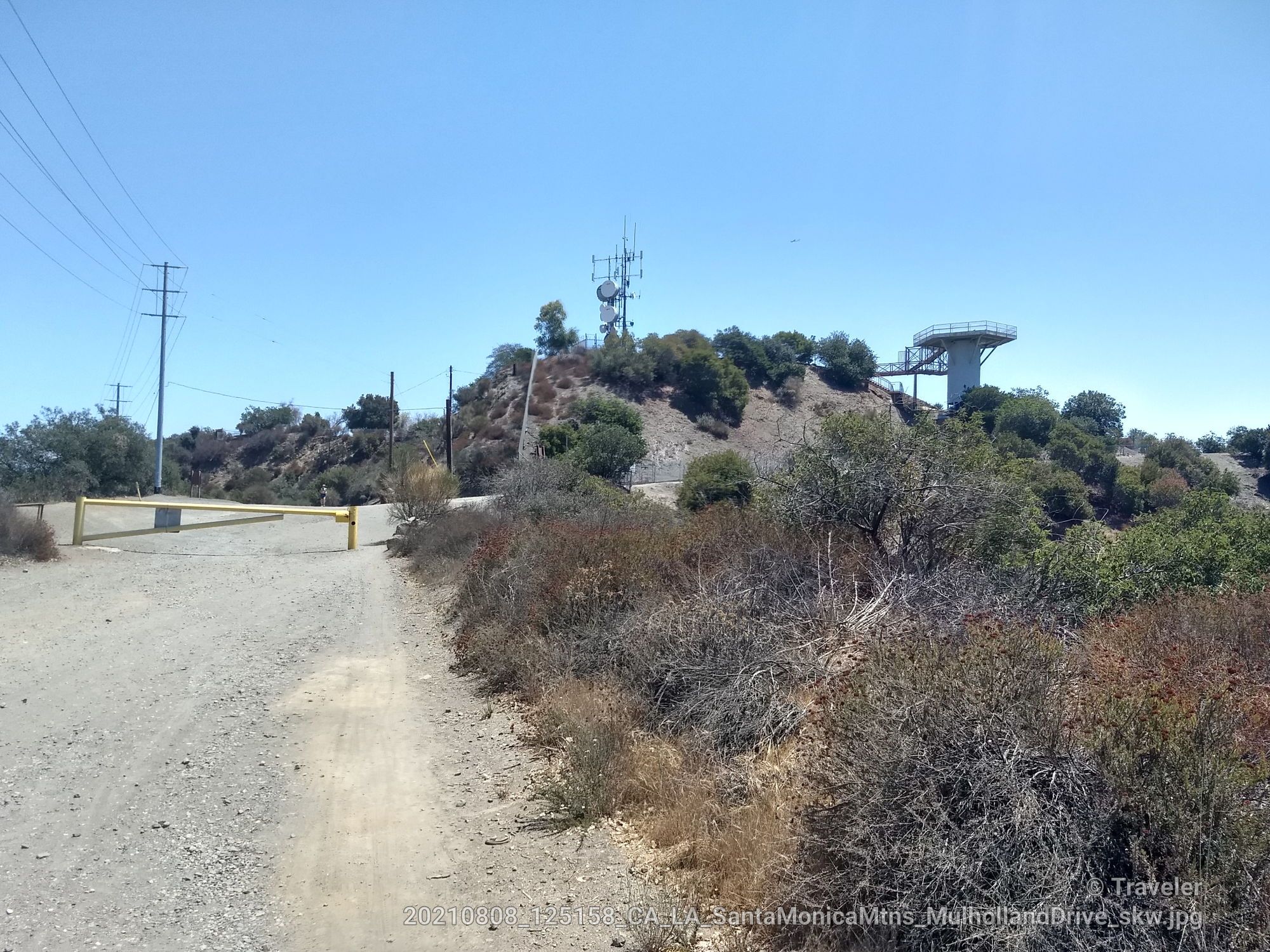 Dirt path leading to a hill with communication towers under a clear sky. - San Vicente Mountain Viewpoint – The Hub (Topanga State Park) loop from Santa Monica Mountains