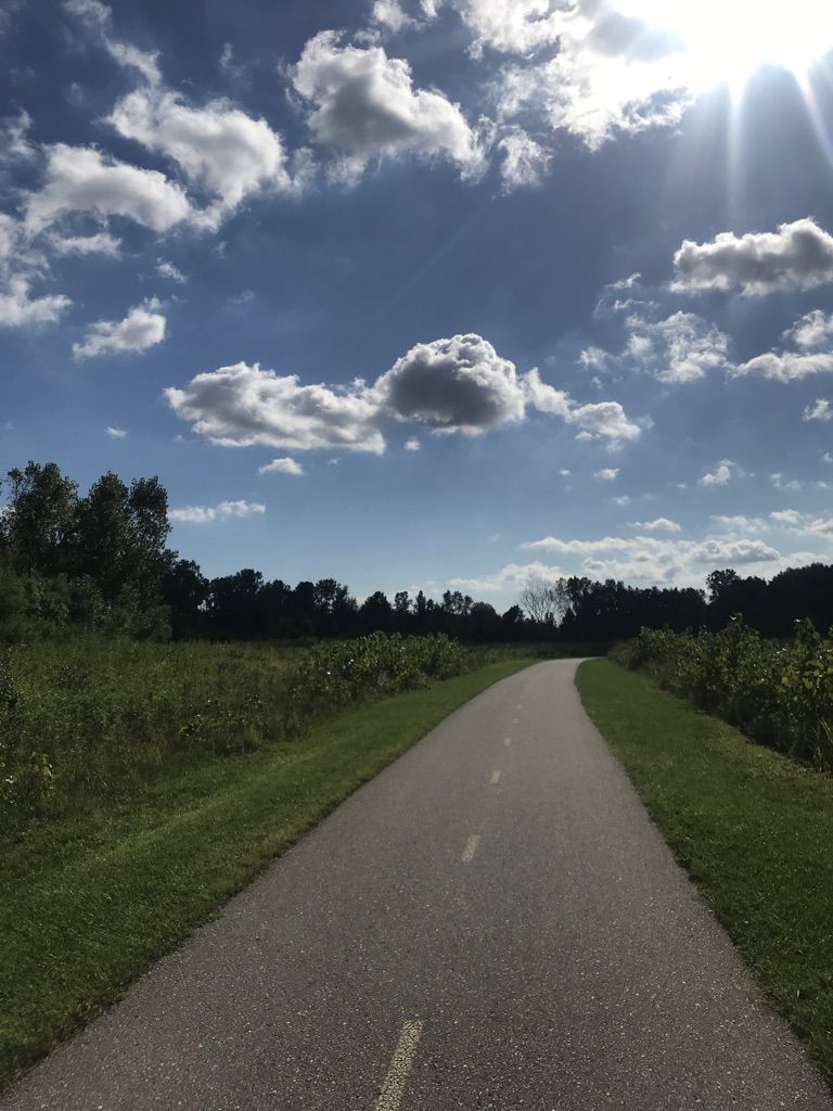 Sunny paved path through green fields under a partly cloudy sky. - Huroc Park loop from Willow