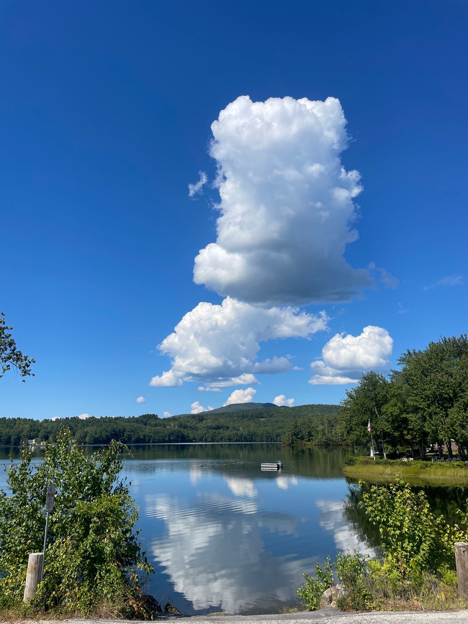 A calm lake reflects a large cloud under a bright blue sky. - Highland Lake – Highland Lake loop from Webster Lake
