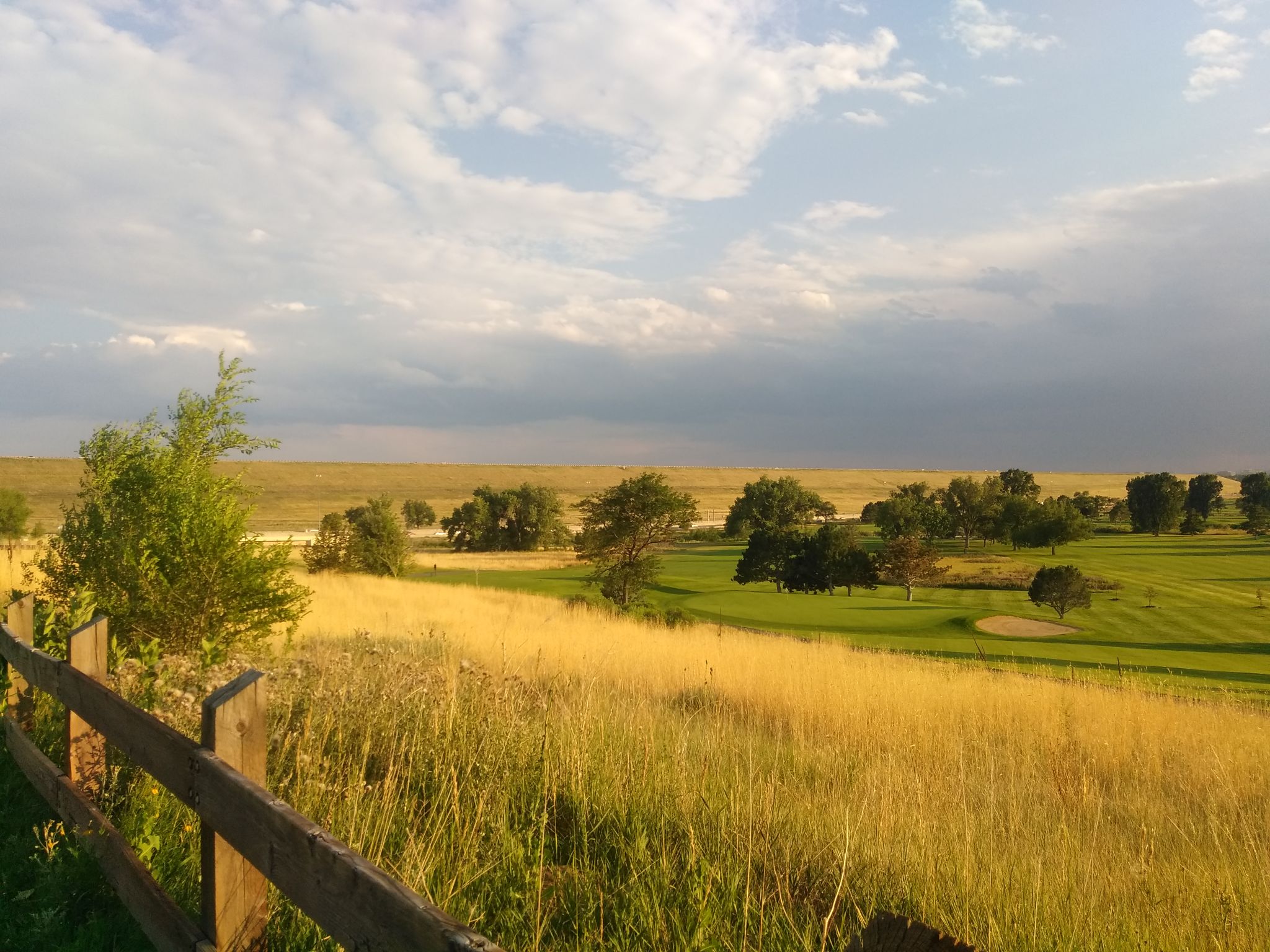 Golden field and green golf course under a partly cloudy sky. - CCT: S2.2 – CCT: 2.3 loop from University of Denver
