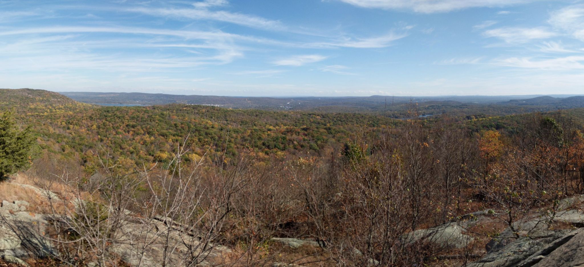 Panoramic view of a vast forested landscape with autumn colors under a bright sky. - Torne Mountain and Osio Rock Loop