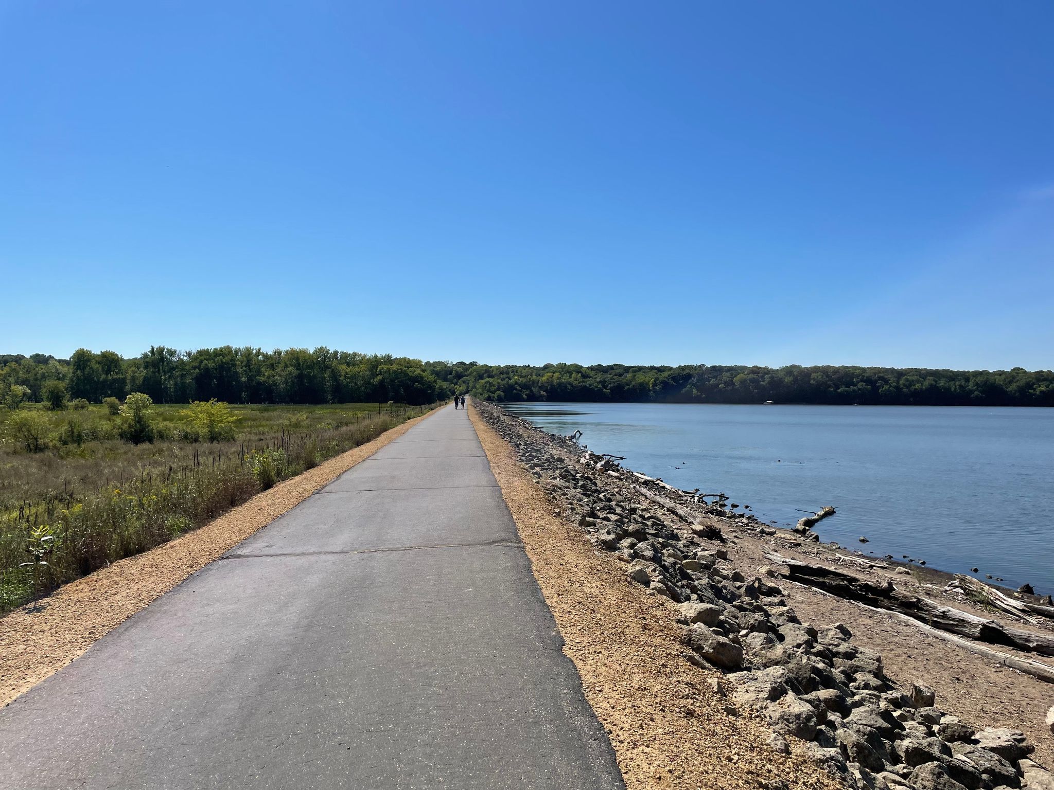 Paved path next to a large body of water under a clear blue sky. - Top of a long climb (Hastings) – Lake Rebecca Overlook loop from Hastings SNA