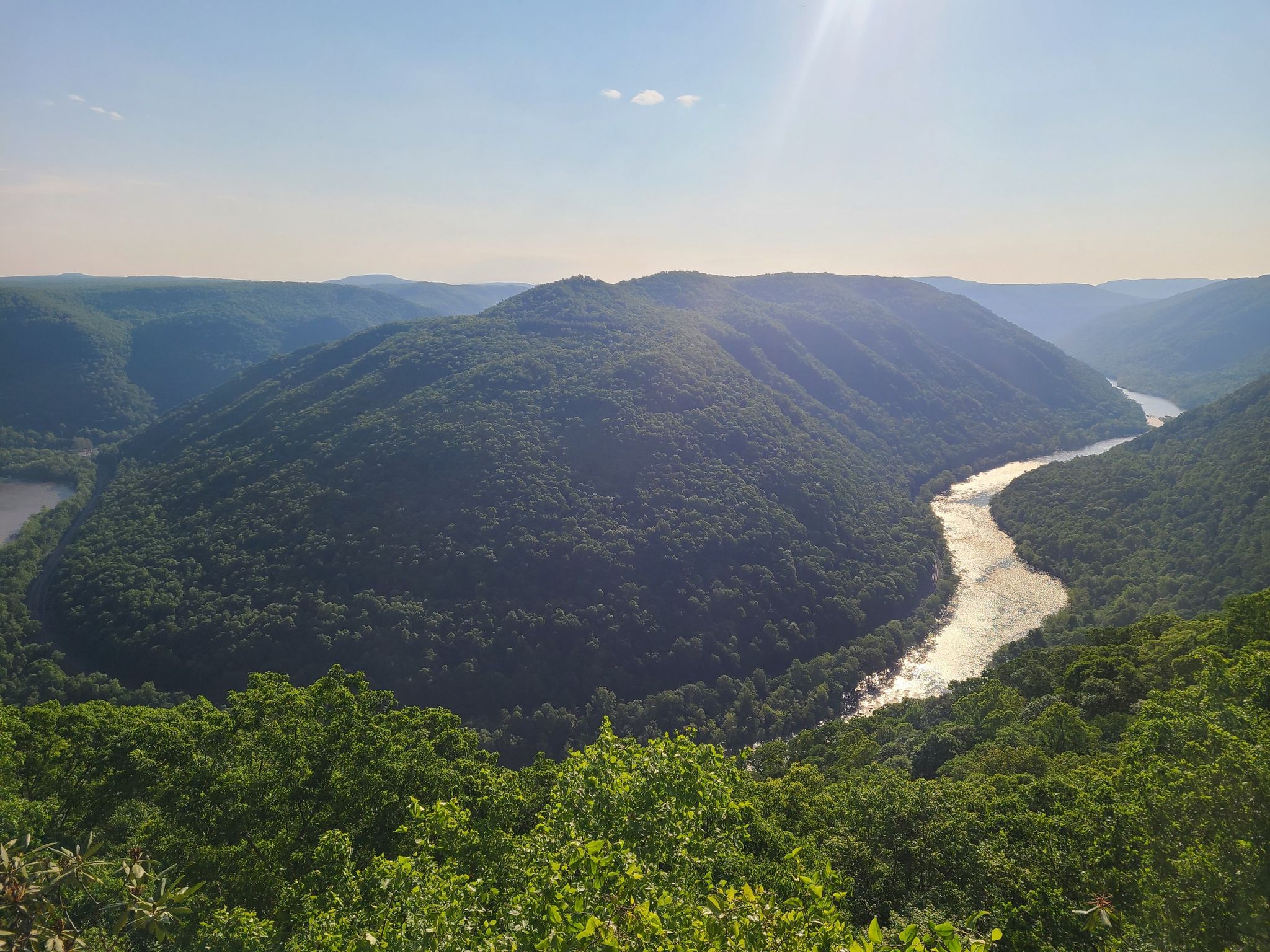 A wide river bends through a vast, sunlit, forested mountain landscape. - Grandview Main Overlook – Castle Rock Trail loop from Grandview
