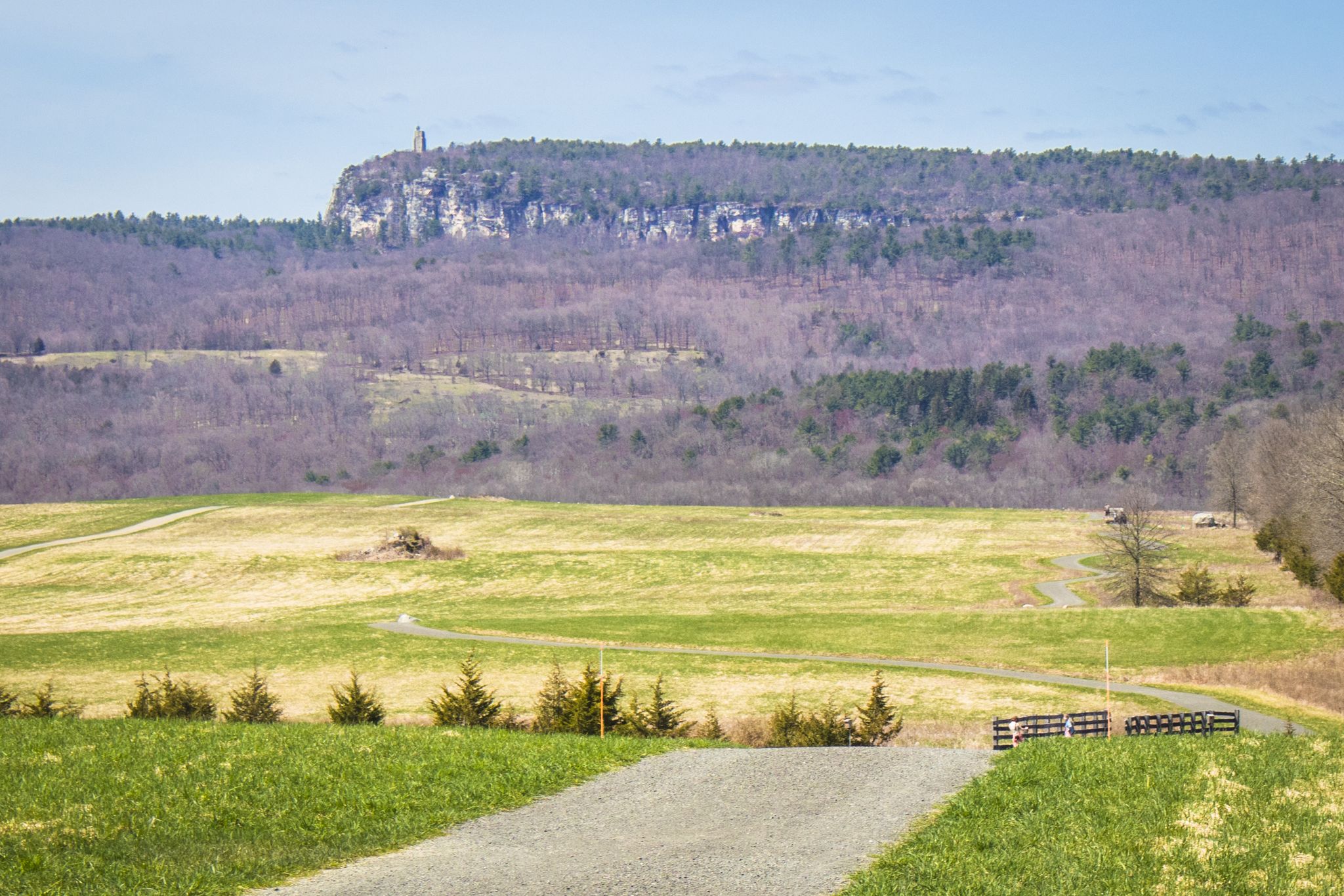 Green fields lead to a distant forested mountain with a prominent cliff. - Duck Pond – Duck Pond loop from Town of New Paltz