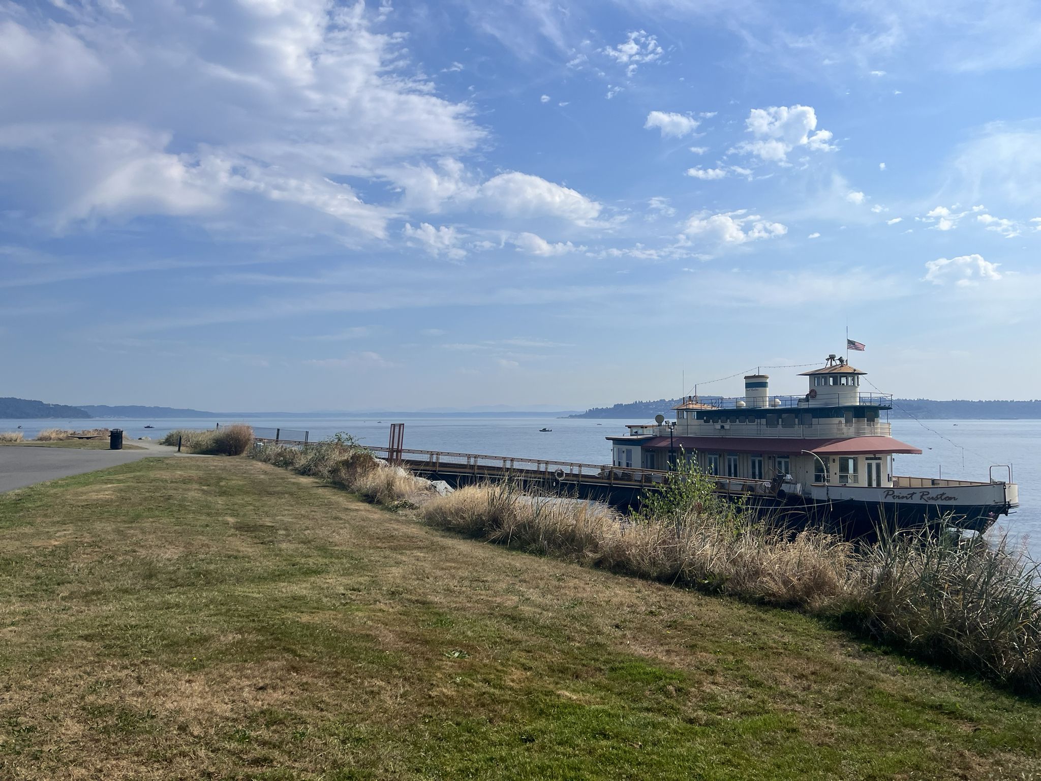 Large boat docked by a grassy bank overlooking calm water under cloudy sky. - Fireboat No. 1 – Dickman Mill Ruins loop from Tacoma