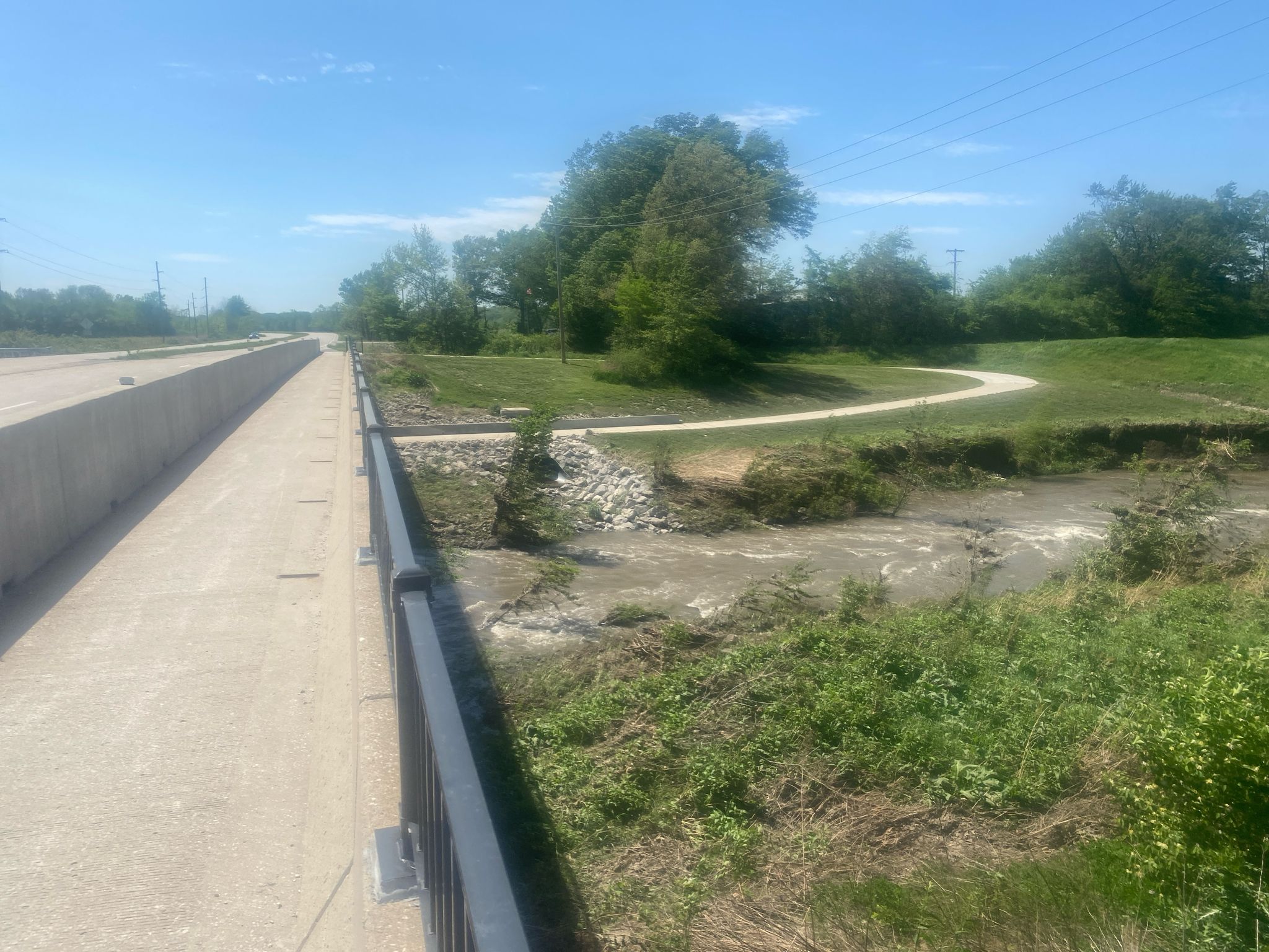A concrete path with railing next to a dry creek and green landscape. - Little Blue Trace Trail – Little Blue Trail Park loop from Independence
