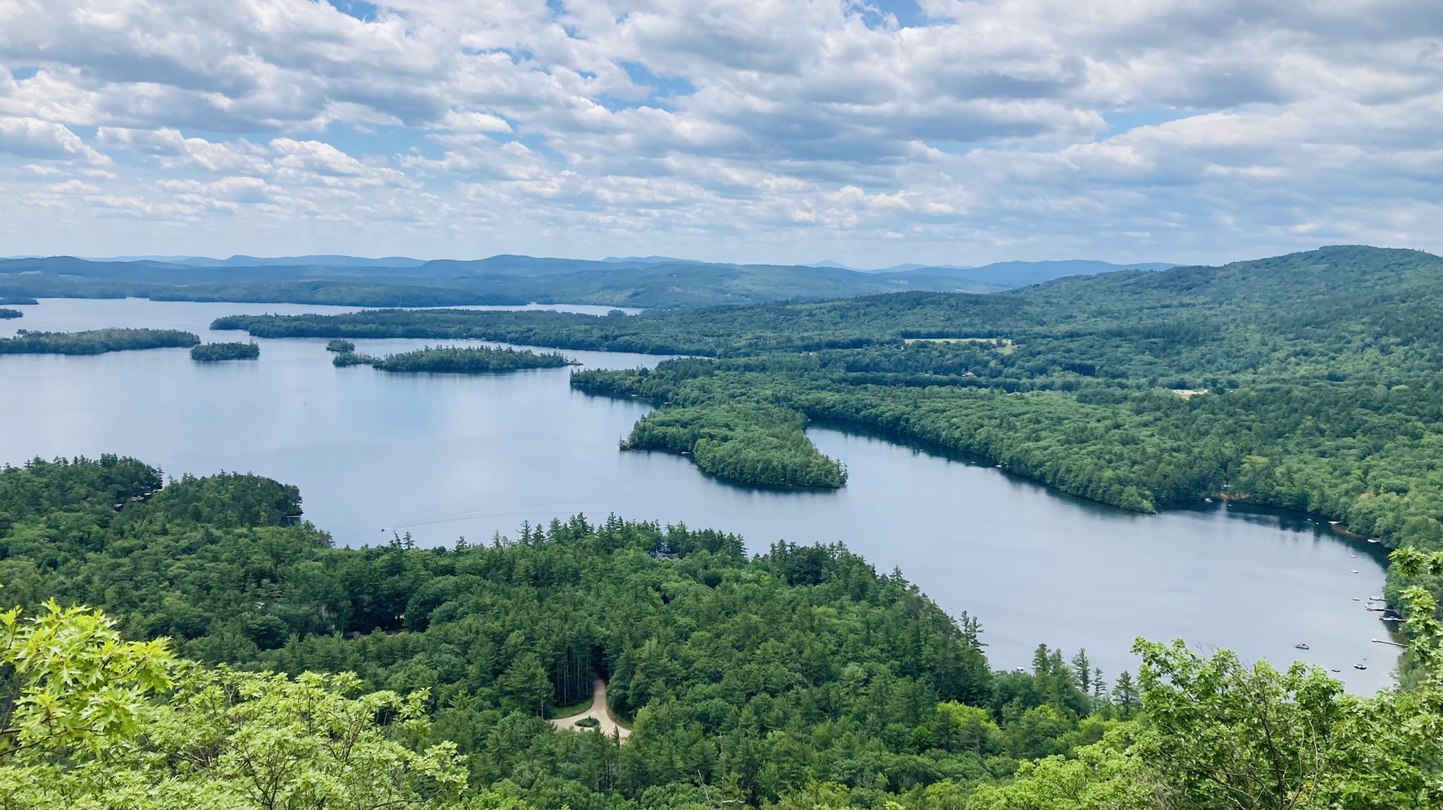 Overcast aerial view of a winding lake surrounded by dense green forests. - West and East Rattlesnake Mountain via Old Bridle Path