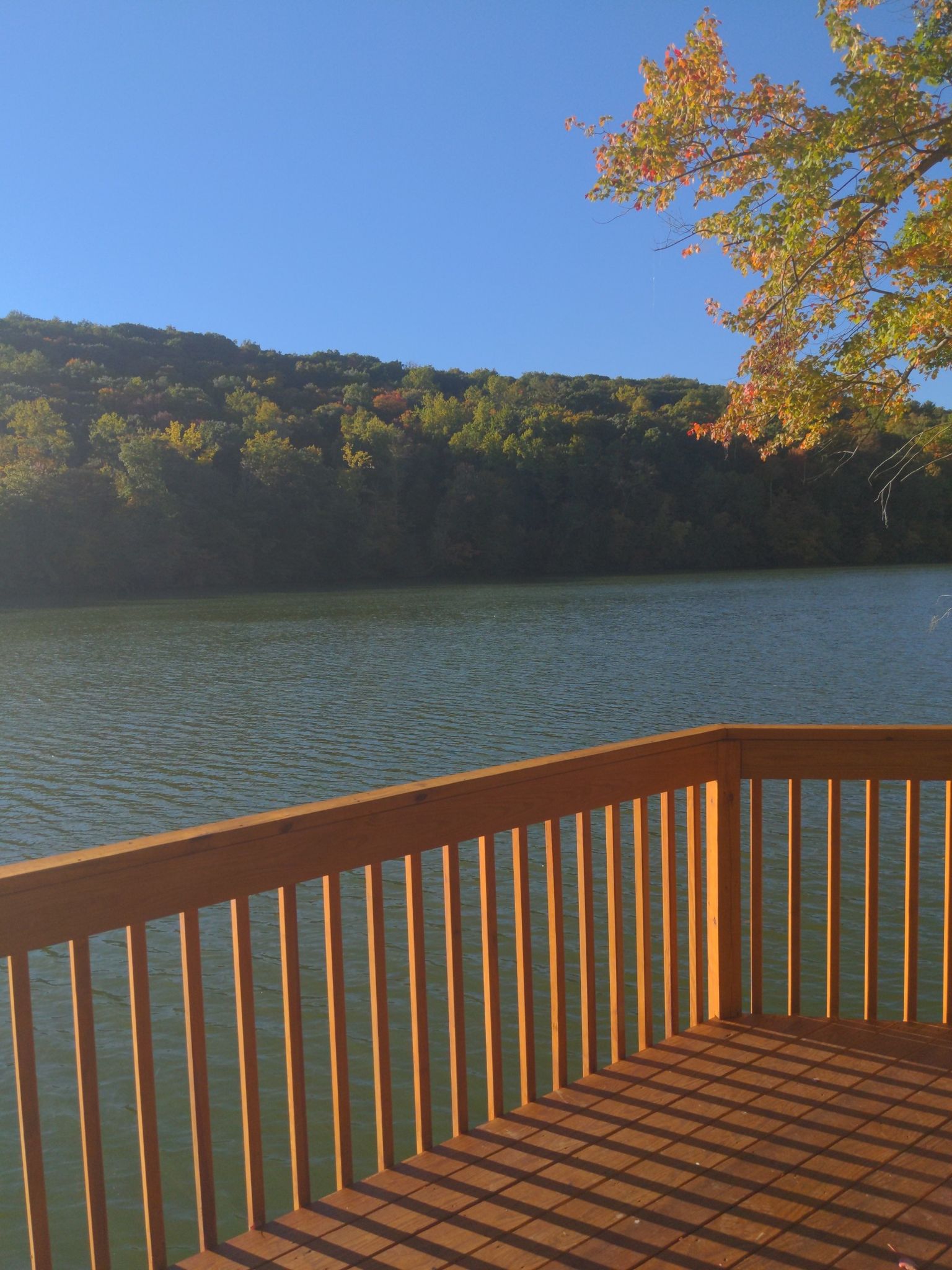 Wooden deck overlooking a calm lake and forested hills under bright sunlight. - Eagle Cliff and Deer Run to Metacomet Trail