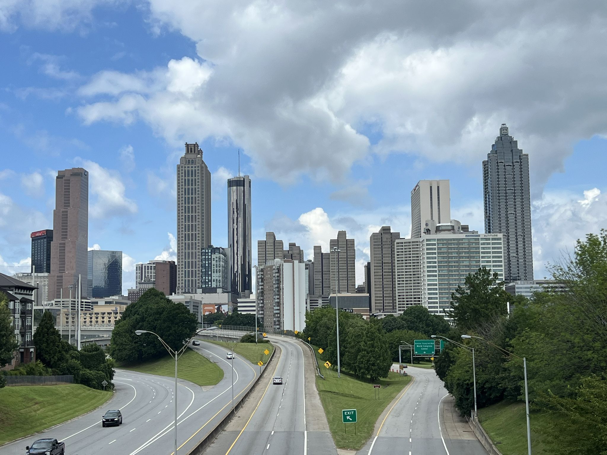 City skyline with tall buildings and a multi-lane highway on a cloudy day. - Grant Park loop from College Park