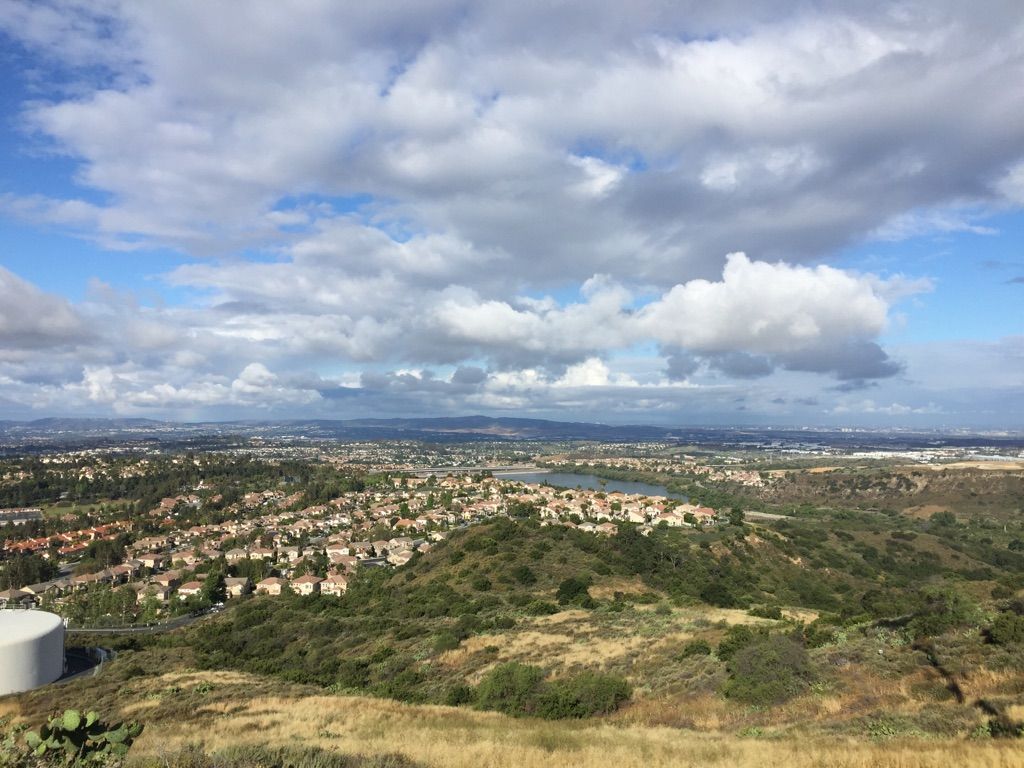 Panoramic view of a town, lake, and hills under a partly cloudy sky. - O'Neill Regional Park – Waterworks Flow Trail loop from Rancho Santa Margarita