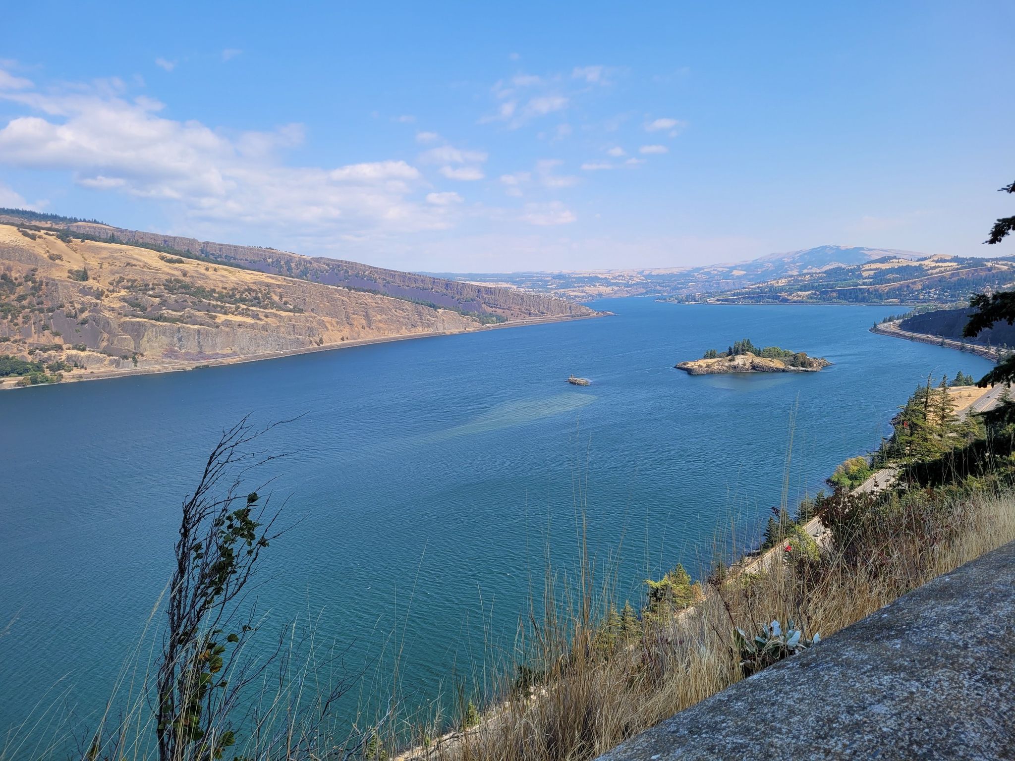 Wide river valley with distant mountains and a small island under blue sky. - Historic Columbia River Highway and Memaloose Hills Loop