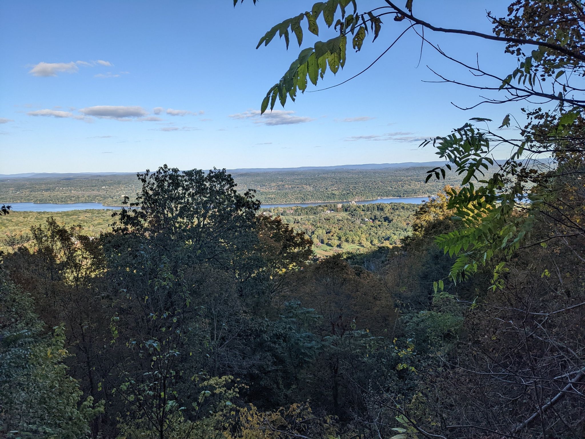 Panoramic view of a forested valley, lake, and distant hills under a blue sky. - Hudson River and Hussey Hill loop from Kingston