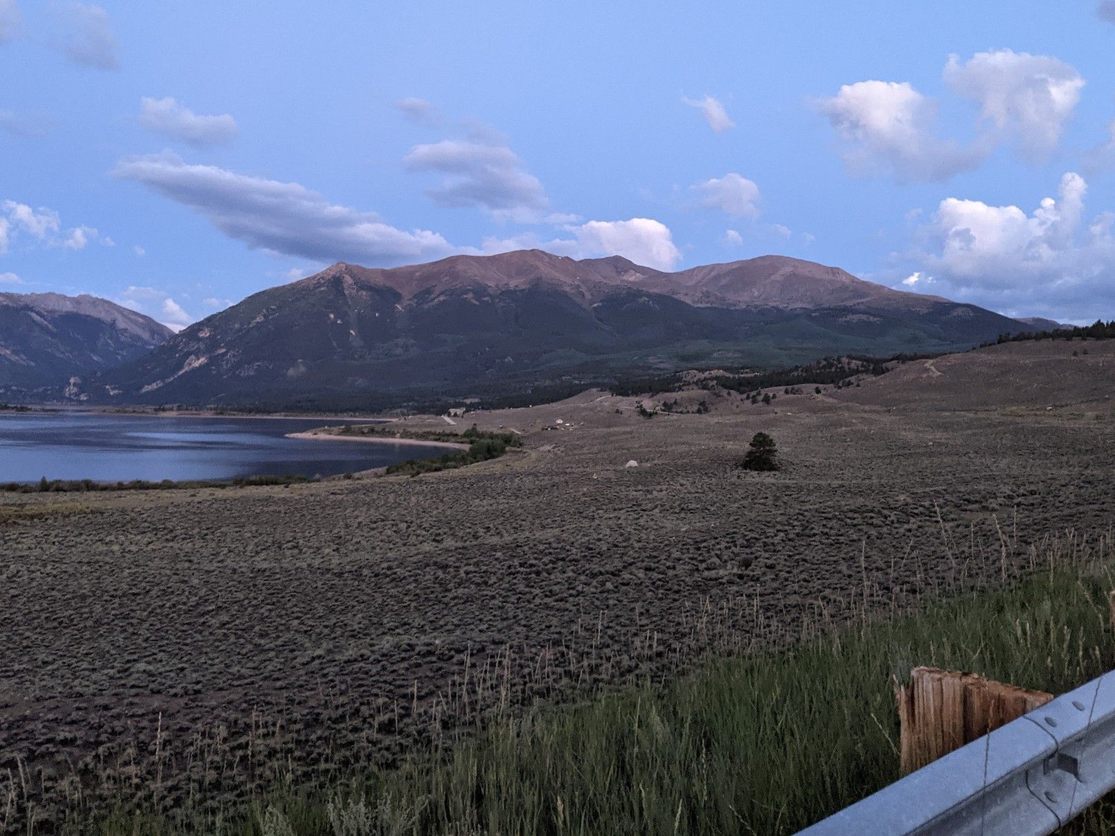 A wide view of a lake, rolling hills, and distant mountains at dusk. - Colorado Trail Segment 11