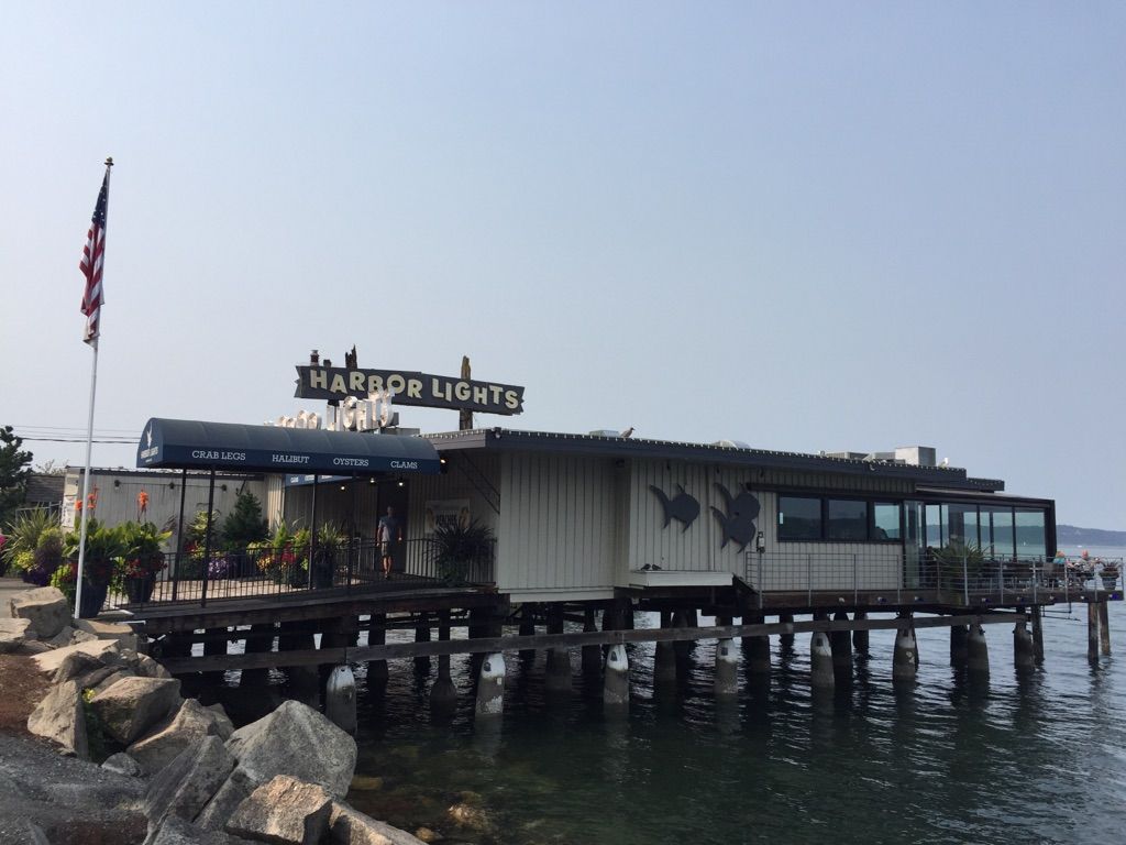 Waterfront restaurant building on stilts over water with a flag flying. - Point Defiance and Ruston Way Loop
