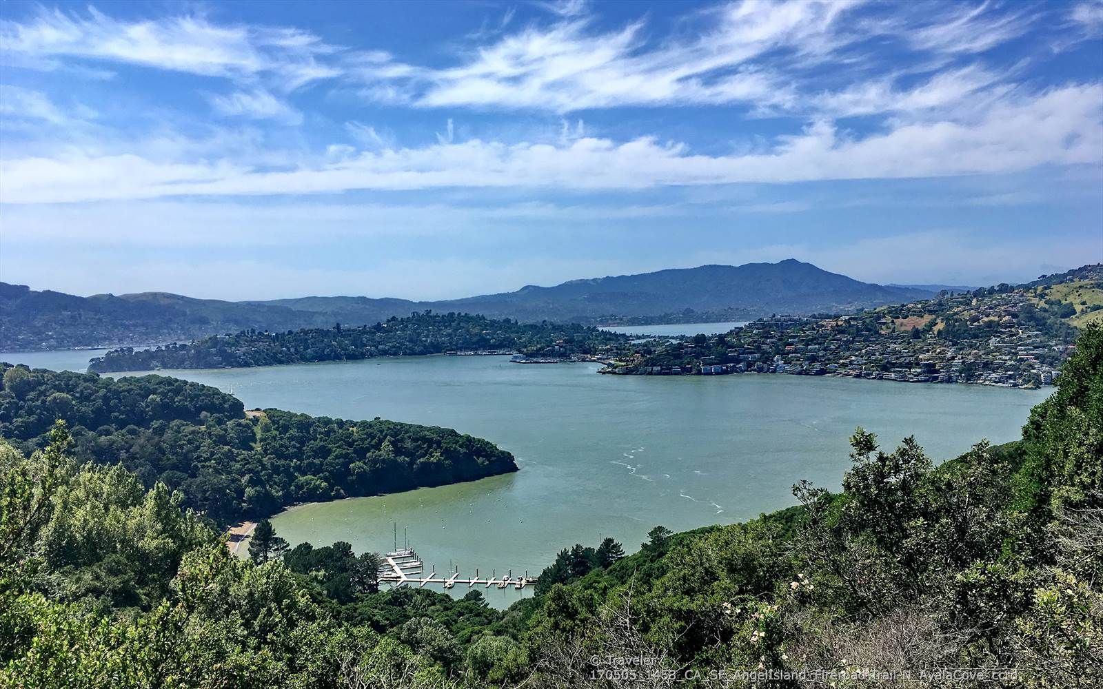 Sunny bay with wooded islands, distant hills, and a cloudy blue sky. - Angel Island Perimeter Loop