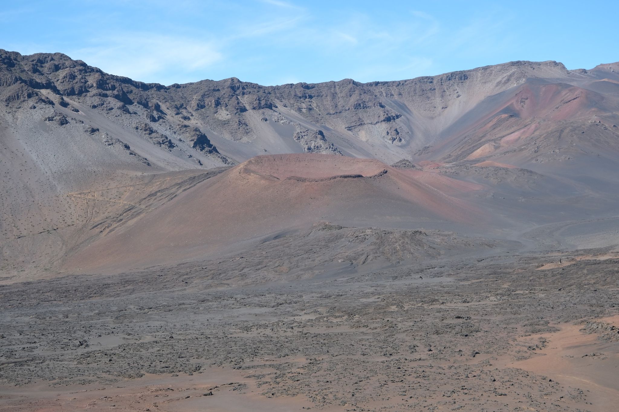 Expansive barren volcanic crater with varied rock formations under a clear sky. - Paia to Haleakalā (Cycle to the Sun)