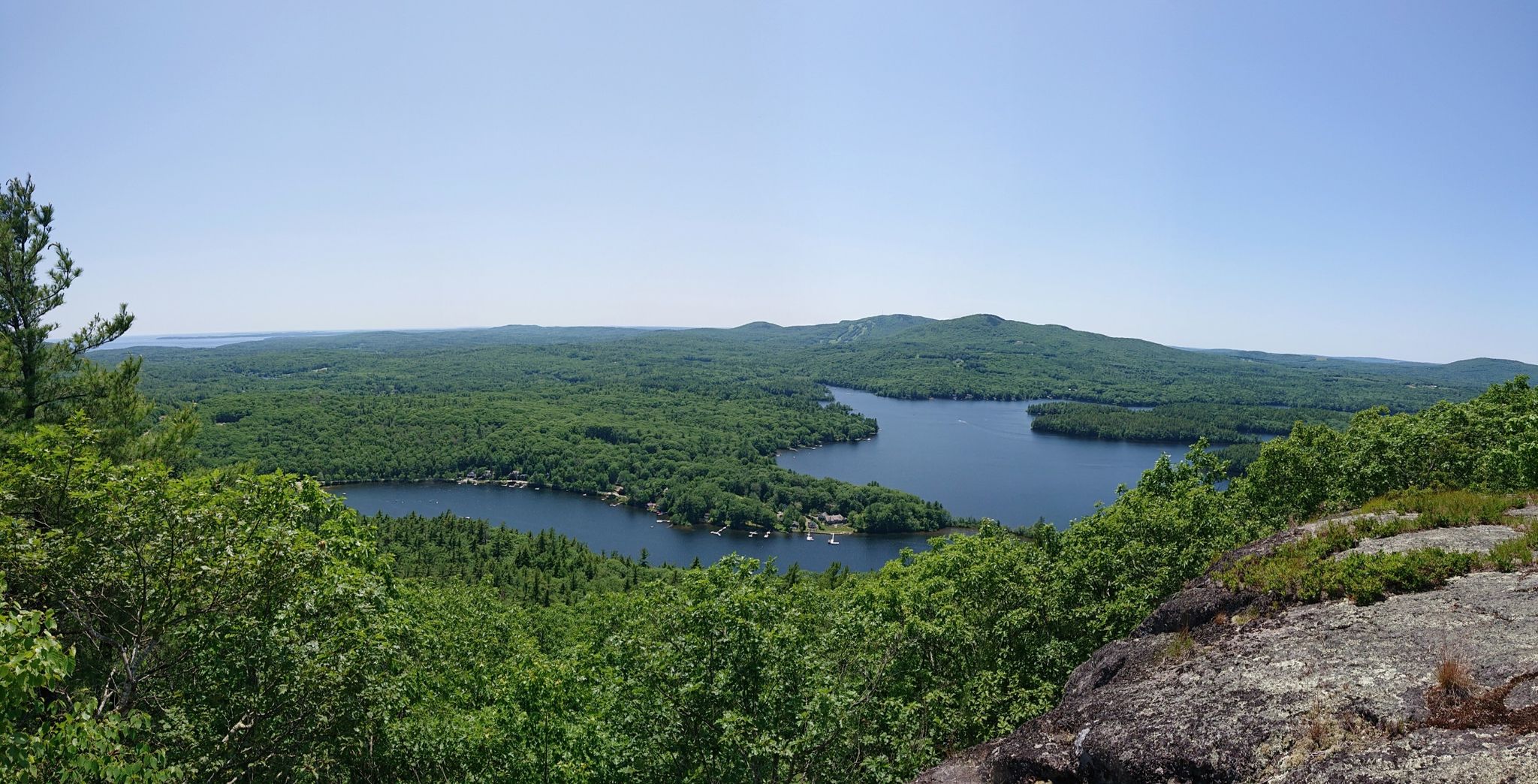 Panoramic view of two serene lakes nestled within dense green forests. - Maiden Cliff Trail