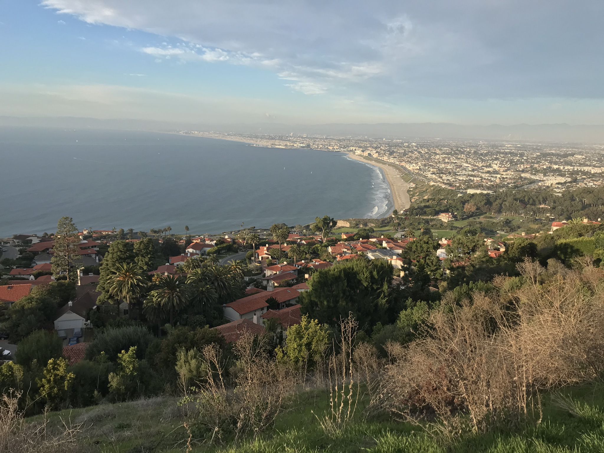 Elevated view of a coastal town and curving beach under a soft cloudy sky. - Redondo Beach – Torrance Beach loop from Redondo Union High School
