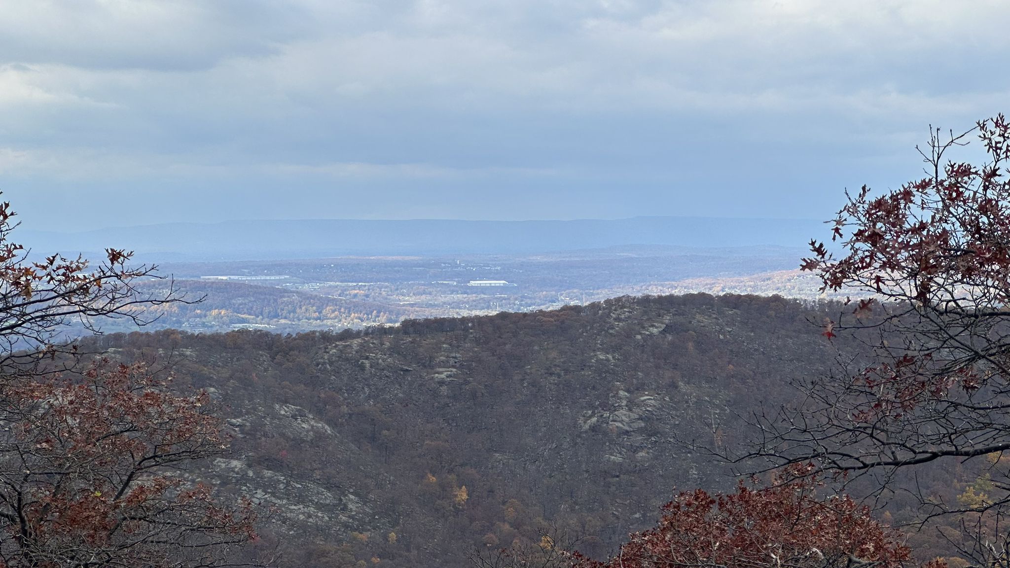 Distant hazy view of a valley and hills under a cloudy sky. - Bull Hill via Lonestar, Nelsonville, and Split Rock Trails