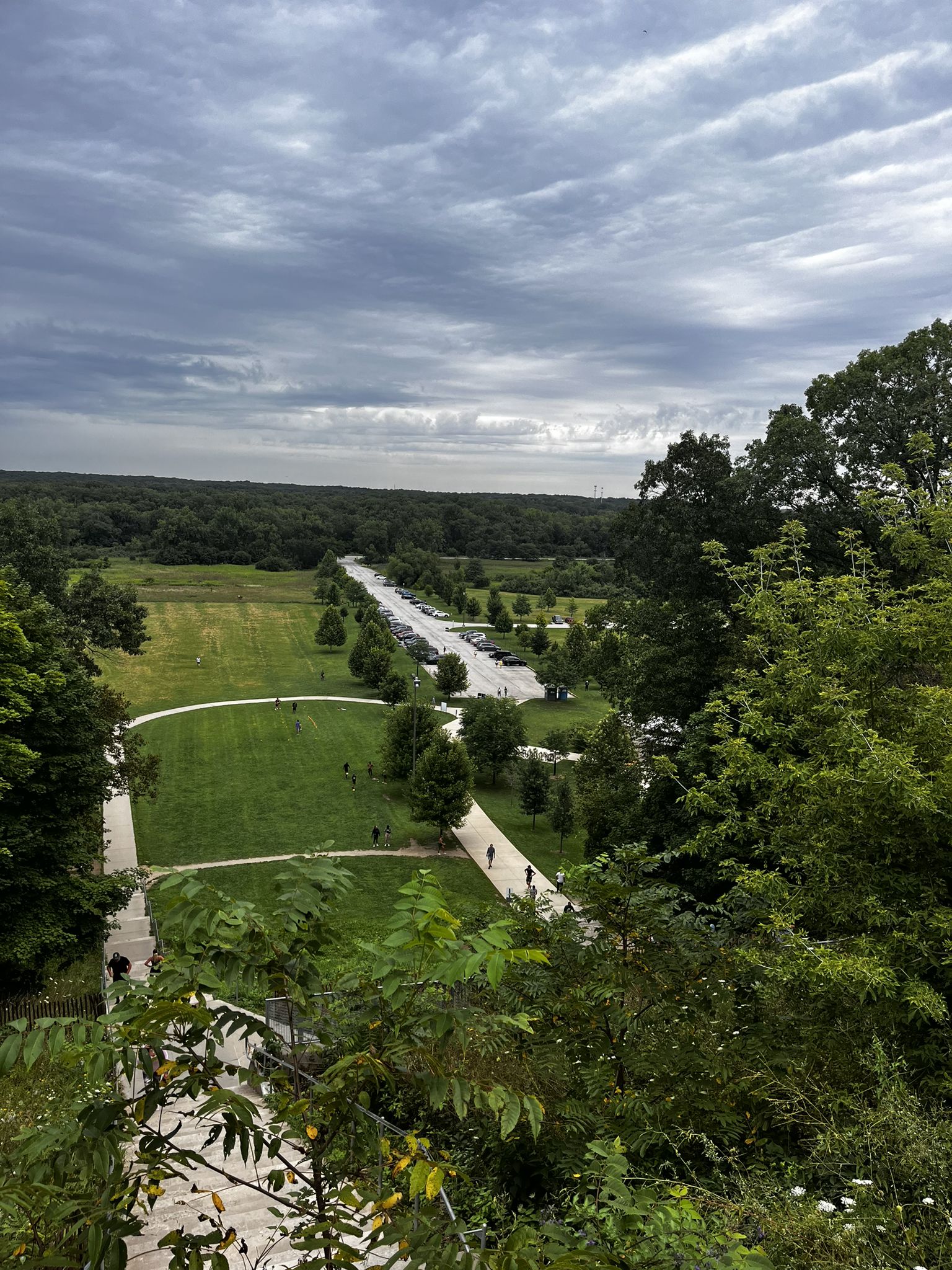 Overlook of a park with paths, trees, and distant fields under cloudy sky. - Sag Valley Yellow and Tan Loop
