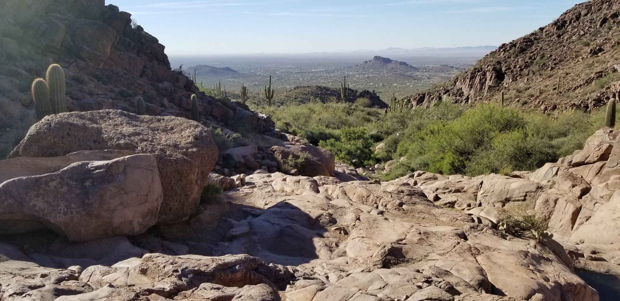 Panoramic view of a rocky desert valley with distant mountains under a bright sky. - Hieroglyphic Trail #101