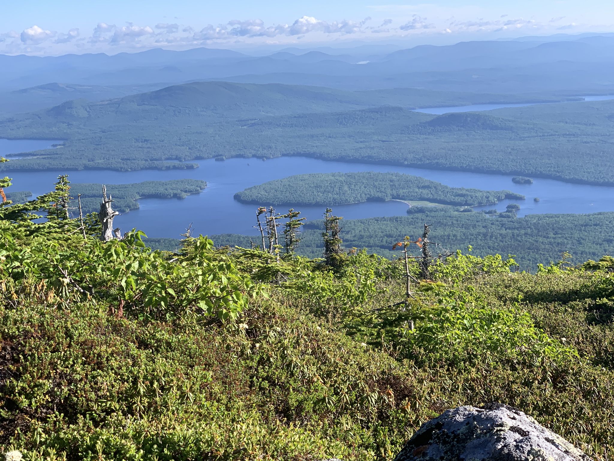 Panoramic mountain view over multiple lakes and dense green forests on a clear day. - Myron H Avery Peak via Appalachian Trail