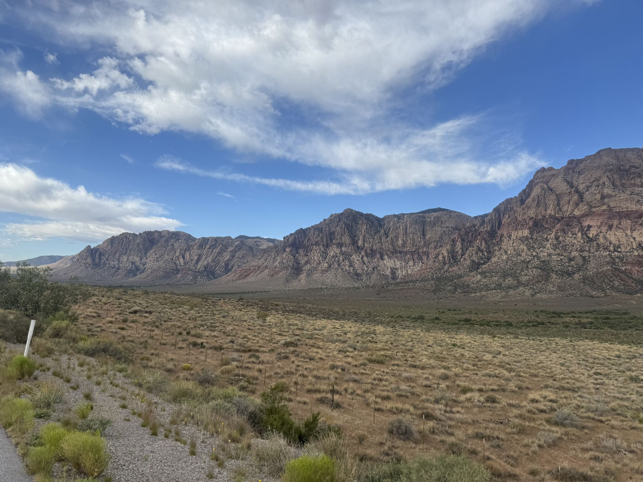 Wide desert valley with distant mountains under a partly cloudy sky. - Red Rock Canyon Overlook – Blue Diamond loop from Summerlin South
