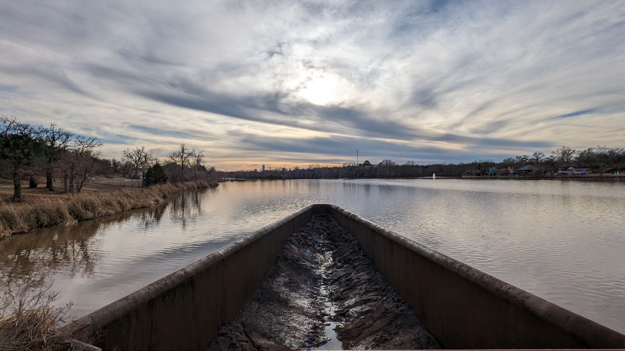 A wide lake under a cloudy sky with sun, viewed from a concrete structure. - Bert Cooper Trails – Lake Hefner Lighthouse loop from School Bus Stop for Mustang Public Schools