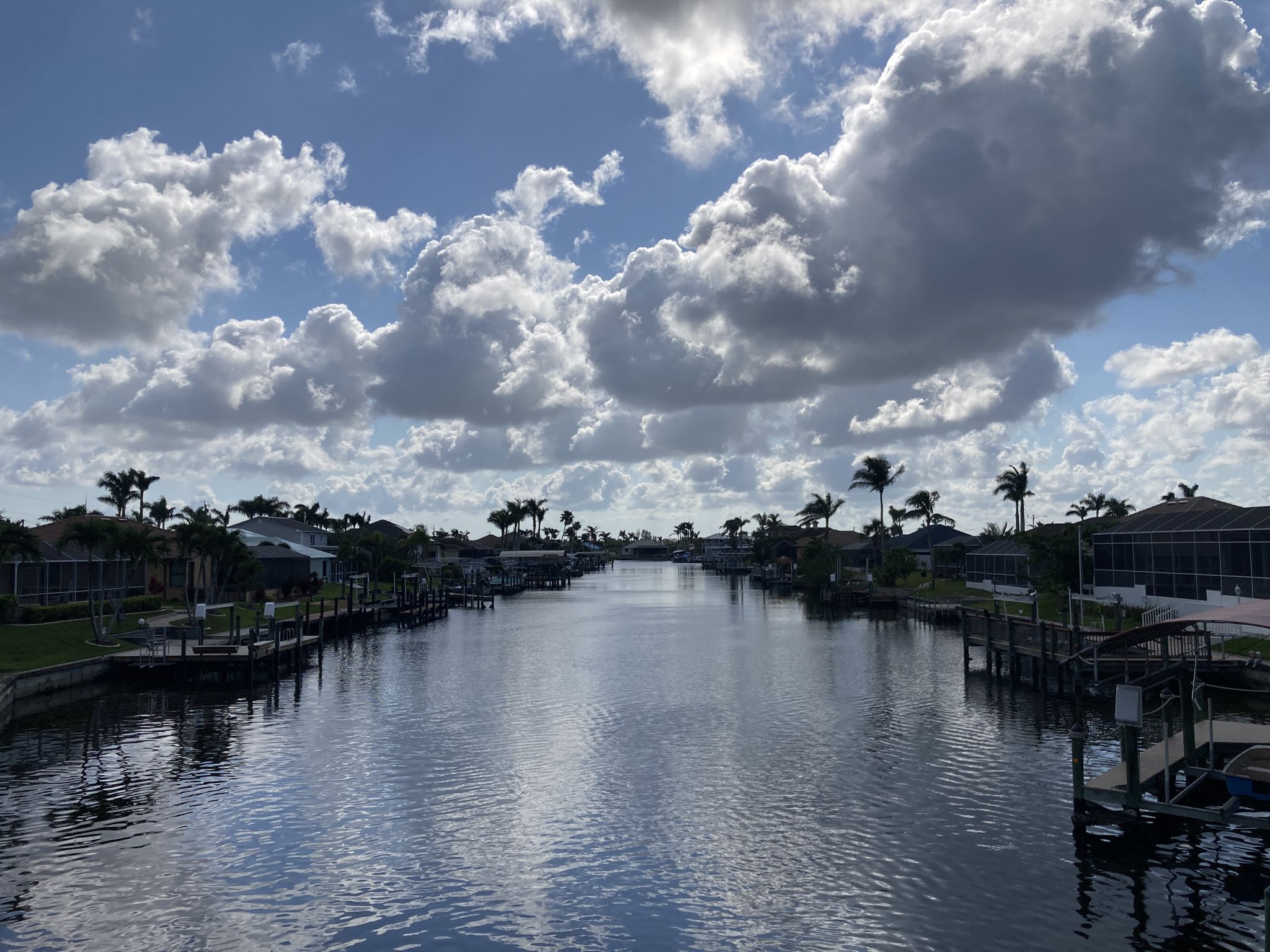 Canal with houses and boats under a partly cloudy sky. - Running loop from Security Checkpoint