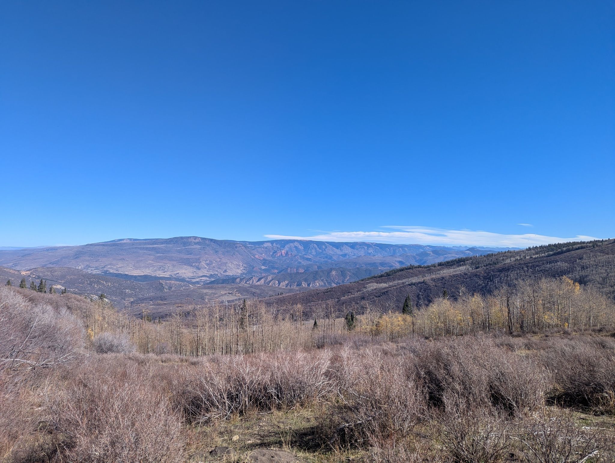 Expansive mountain valley under a clear blue sky with dry brush. - Thomas Lakes Trail