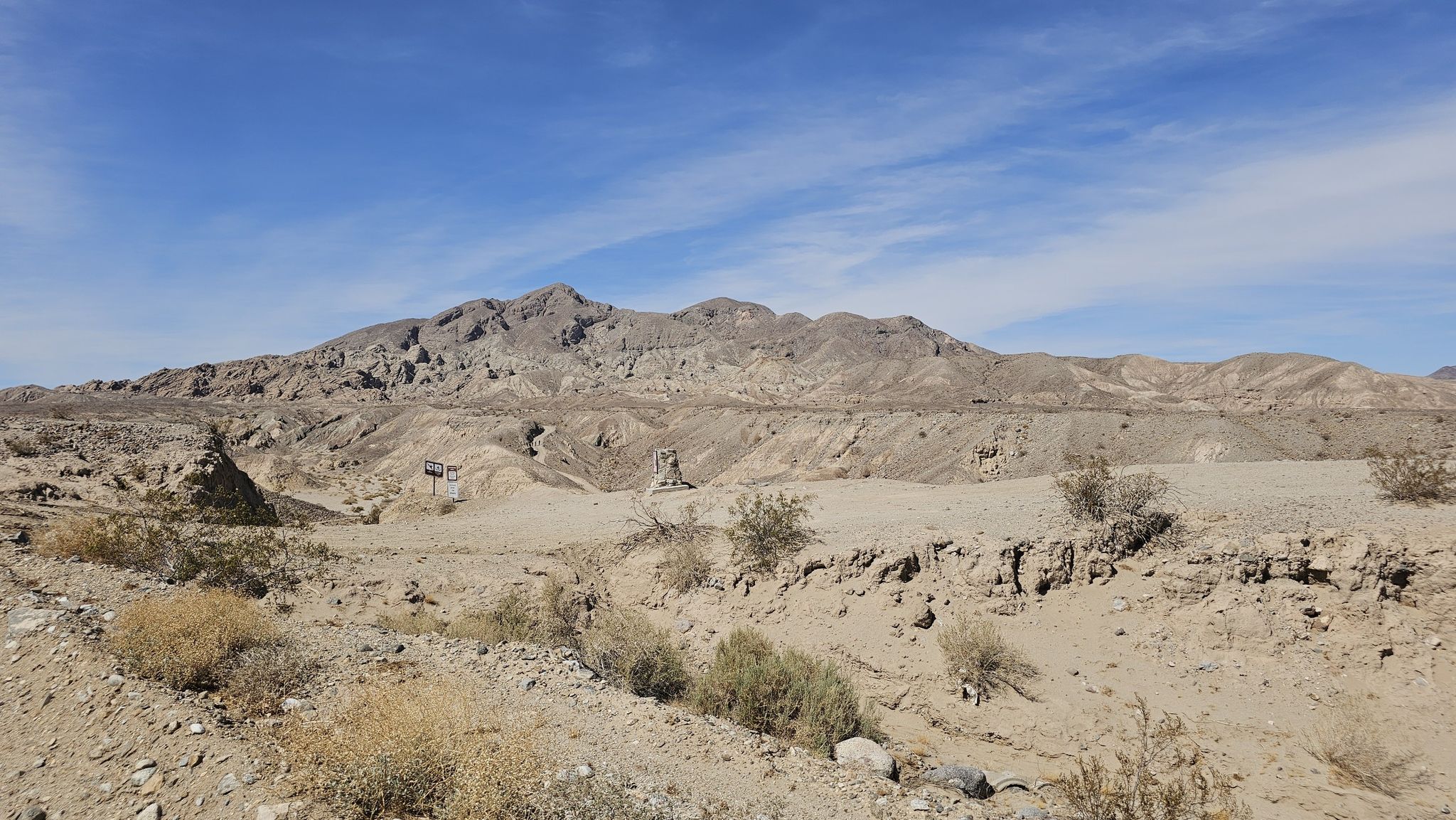 Arid desert landscape with rocky mountains under a bright blue sky. - Calcite Mine Trail
