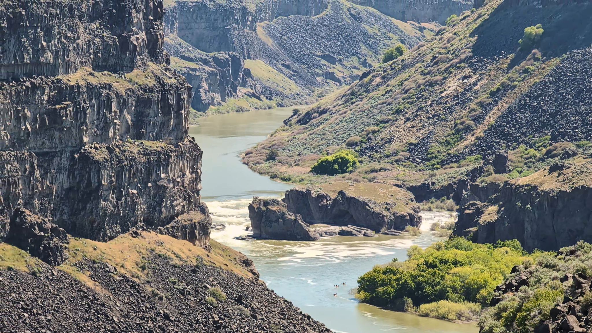 River flowing through a rugged canyon with rocky cliffs and green banks. - Perrine Bridge - Twin Falls loop from The Church of Jesus Christ of Latter-day Saints
