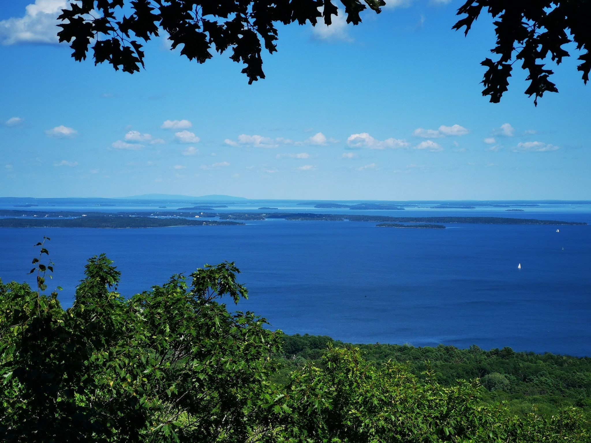 Expansive view of a deep blue lake under a bright, clear sky. - Mount Battie and Mount Megunticook Loop