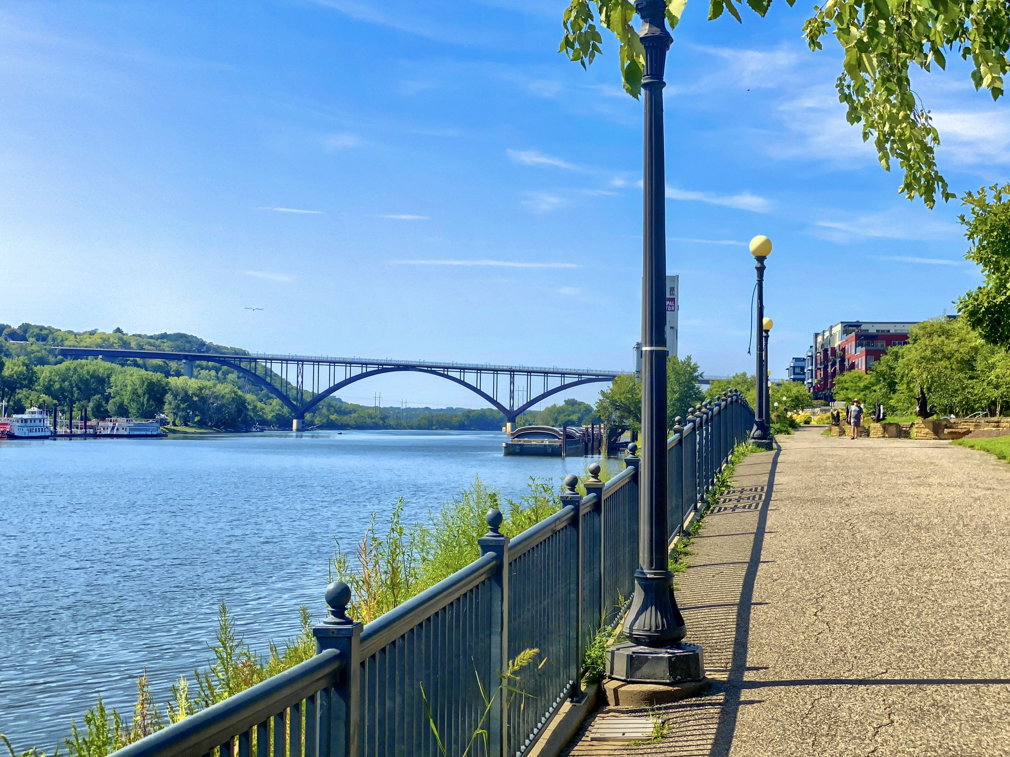 Riverside paved path with a black fence, streetlights, and a large arched bridge. - Battle Creek Regional Park – Upper Landing Park loop from Applewood Neighborhood Preserve