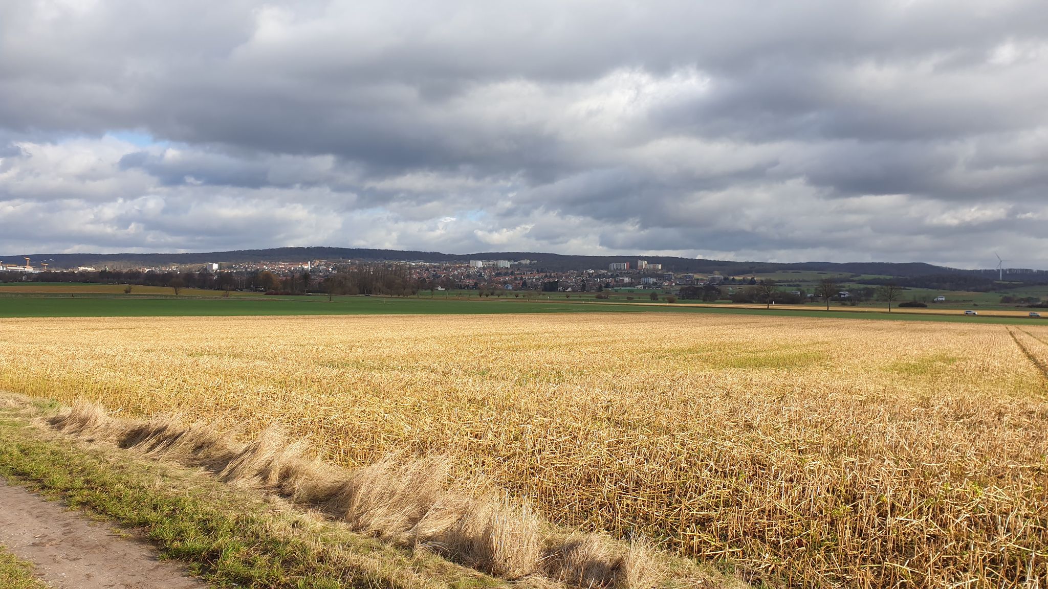Blick über die sonnige Feldmark zum schattigen Geismar.