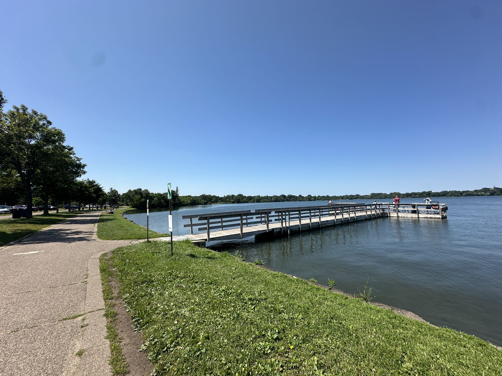 Long wooden pier extending into a lake on a bright sunny day. - Bde Maka Ska – Thomas Beach loop from Linden Hills