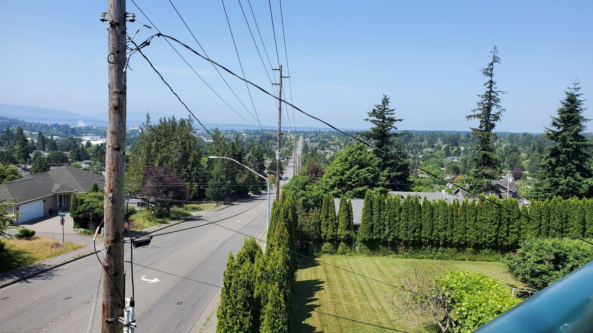 Overhead view of a town with houses, streets, power lines, and distant mountains. - Railroad Trail