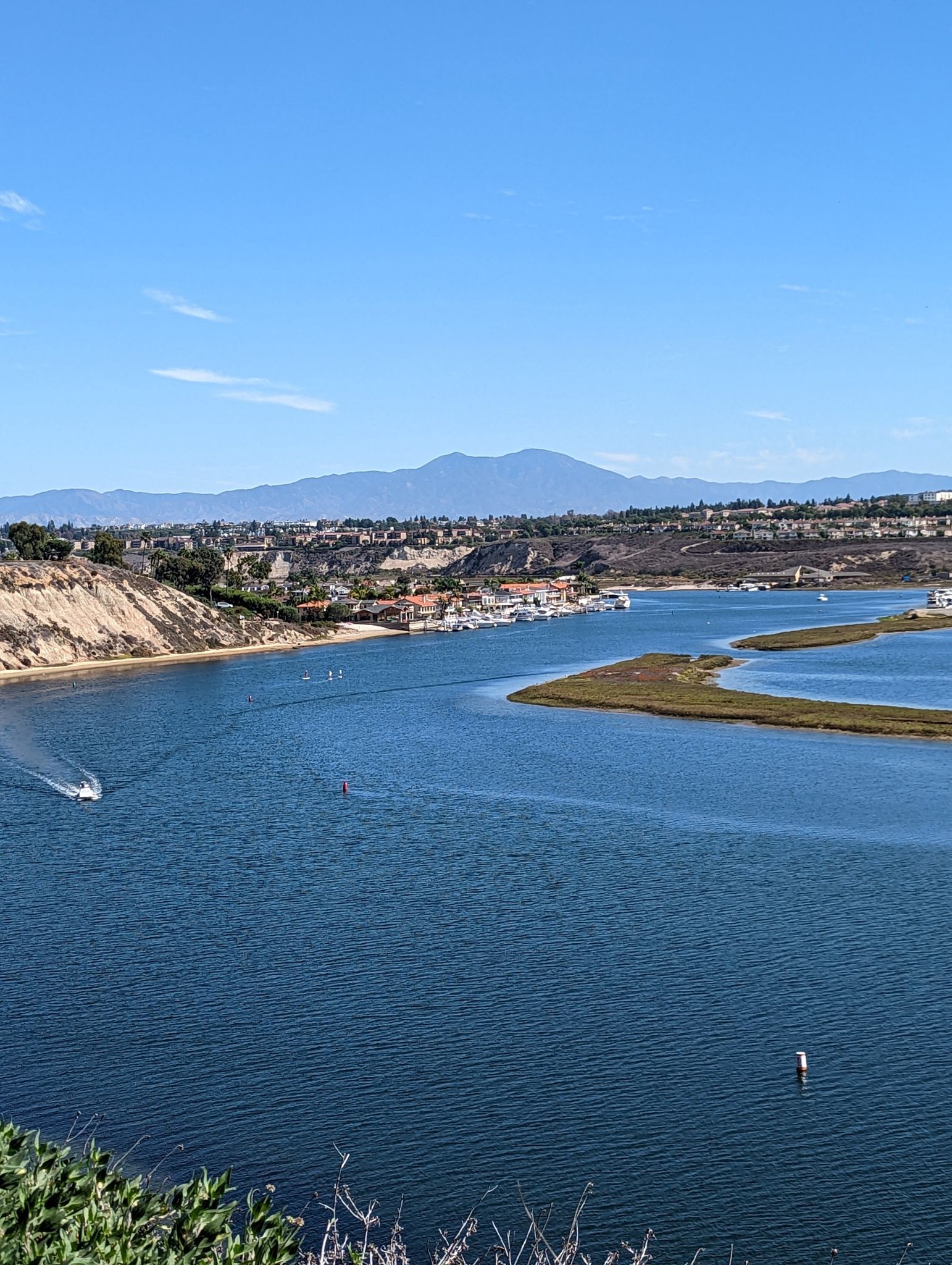 Expansive blue waterway with boats, distant mountains, and coastal homes. - San Diego Creek views – Back Bay Loop Trail loop from Costa Mesa