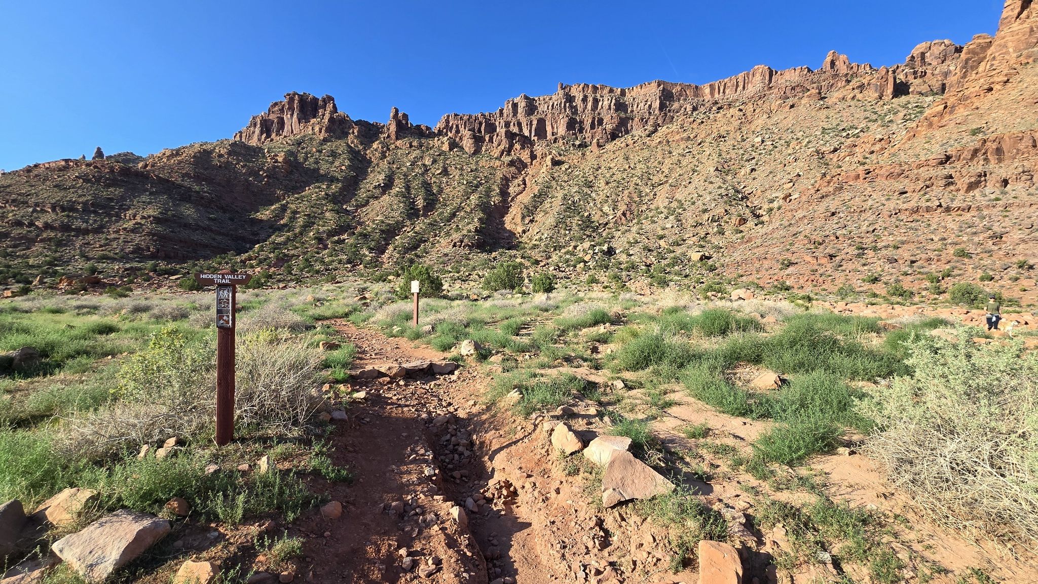 Dirt trail with markers leading into a desert valley with red cliffs. - Pipe Dream trail – Pipe Dream from Aspen Bridge loop from Shell