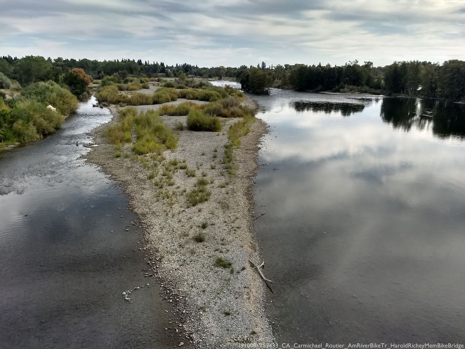 River with a long gravel bar and green shrubs under cloudy sky. - Lake Natoma – Bridge over American River loop from Historic Folsom
