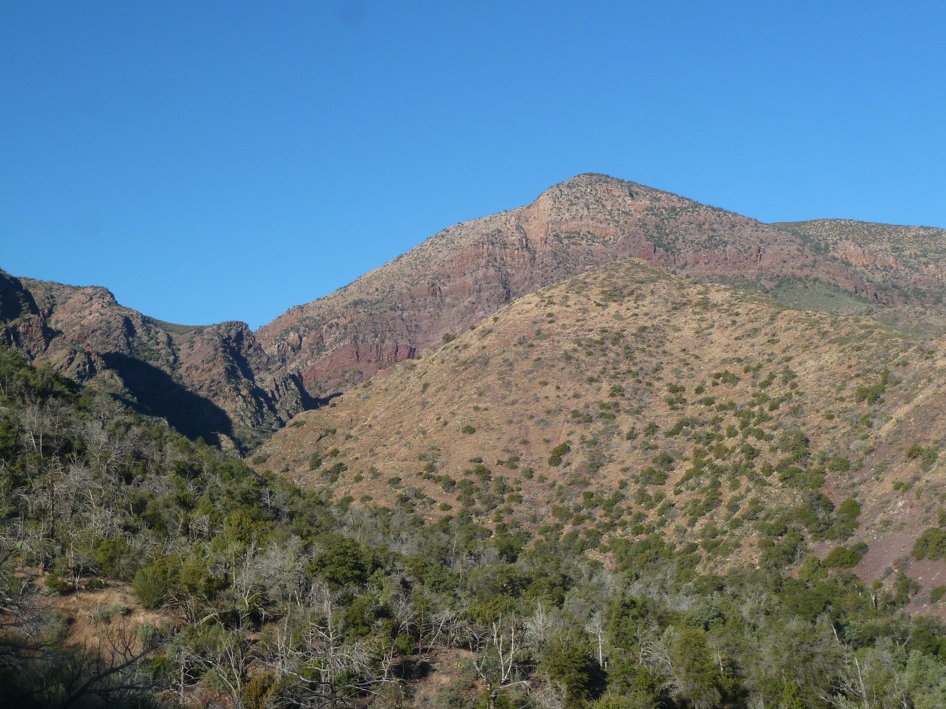 Arid mountain peak and surrounding hills under a bright blue sky. - Barnhardt Trail Waterfall