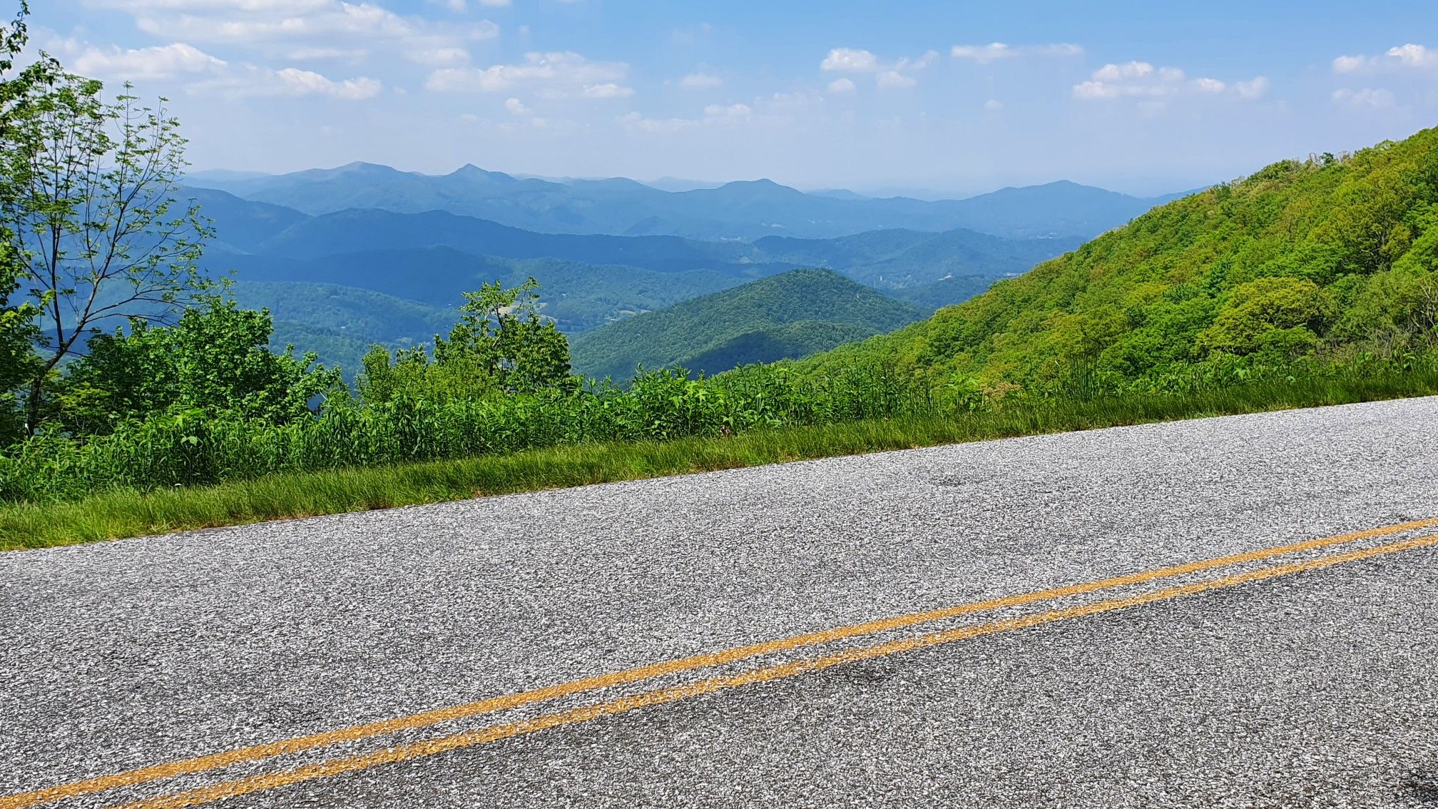 Paved road overlooking distant green mountains under a bright sky. - Walnut Cove View – Pine Mountain Tunnel loop from Silver Line Station