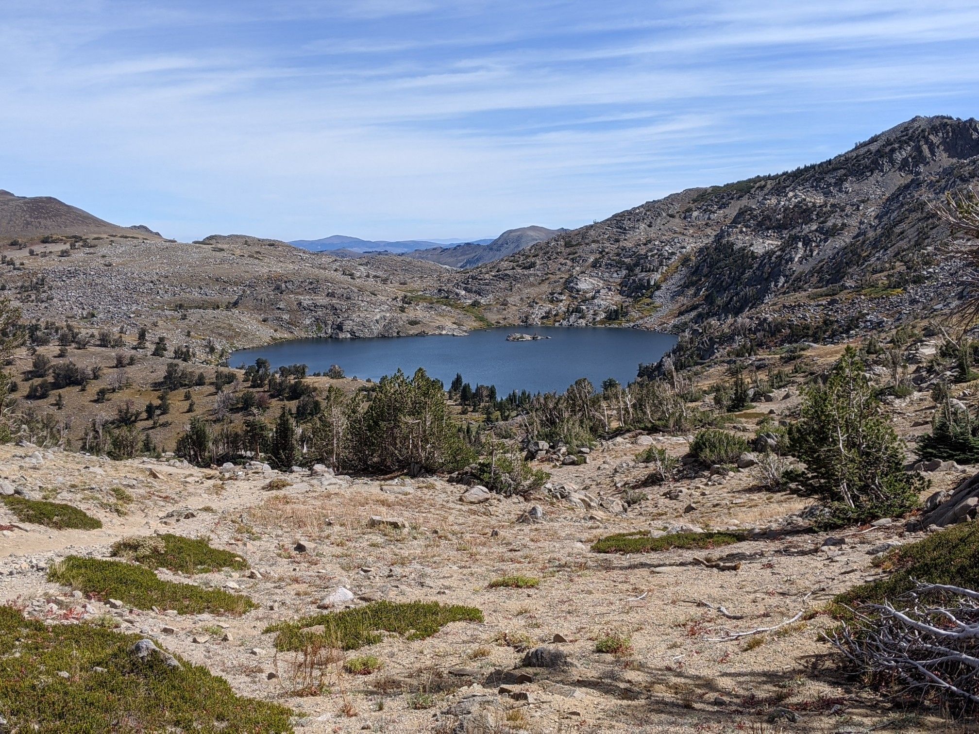Blue lake surrounded by rocky, sparse mountains under a clear sky. - Winnemucca and Round Top Lakes