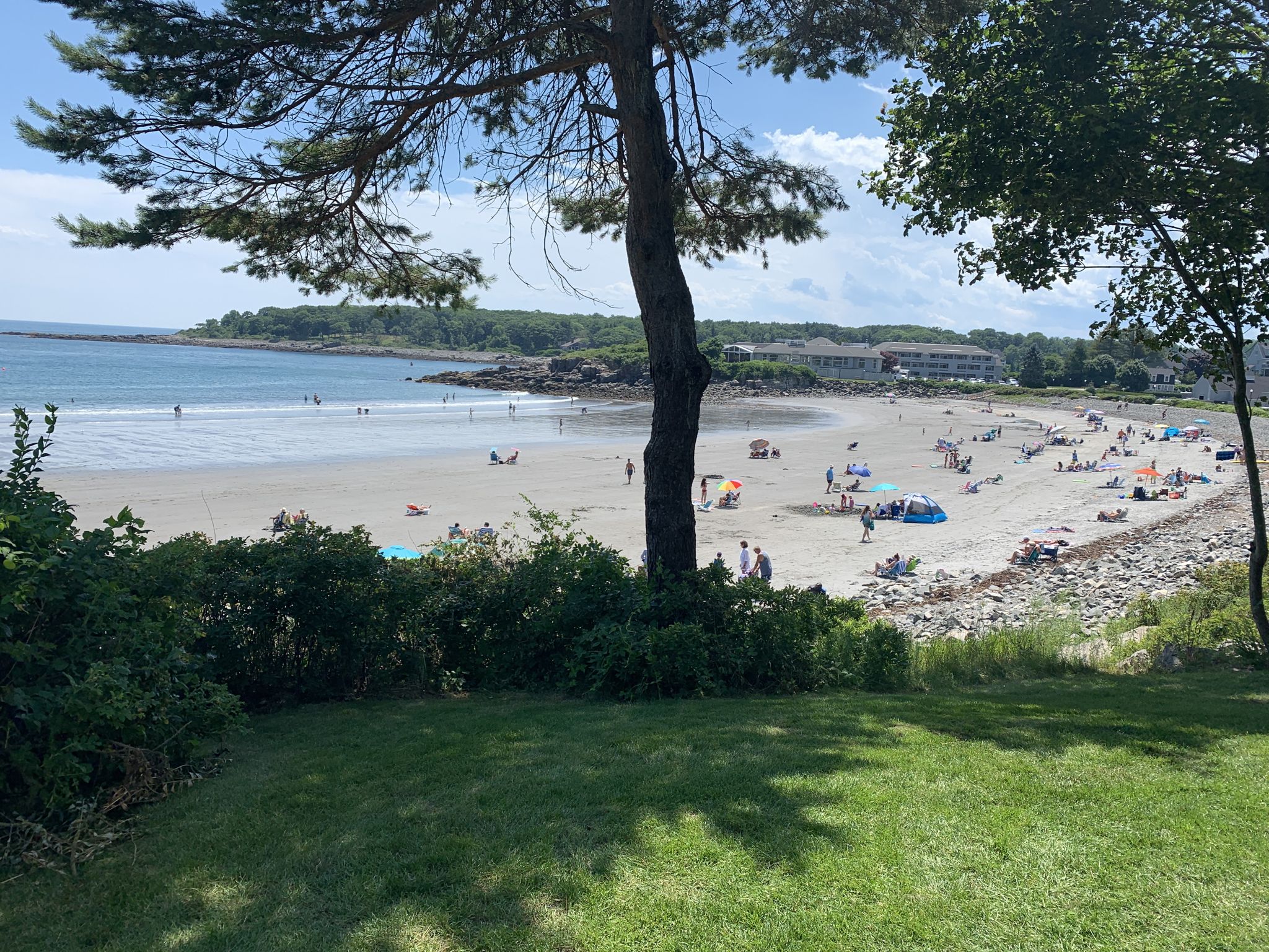 Sunny day at a crowded beach with many people and calm ocean. - Cliff Walk and Fisherman's Walk Loop