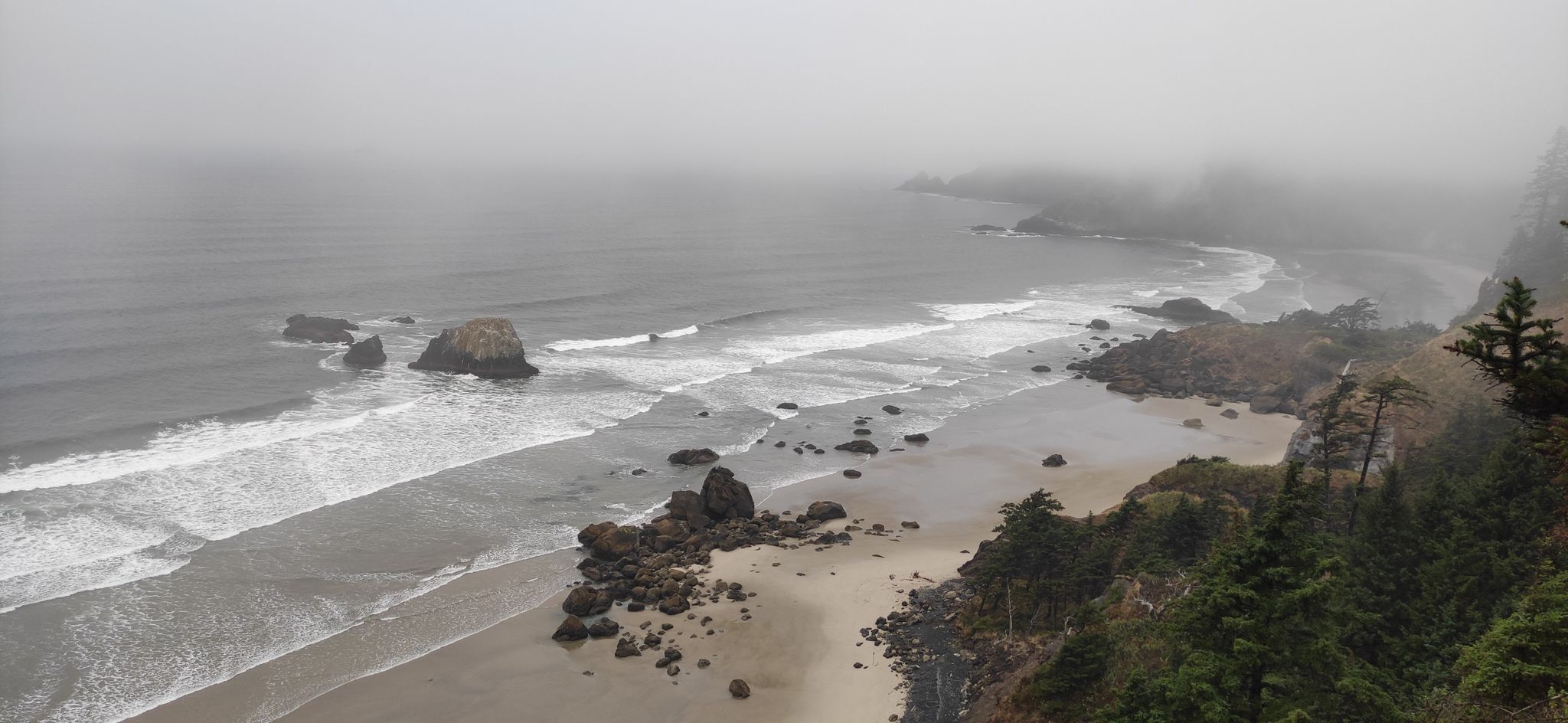 Misty, foggy view of a wide beach, ocean, and sea stacks. - Indian Beach Trail