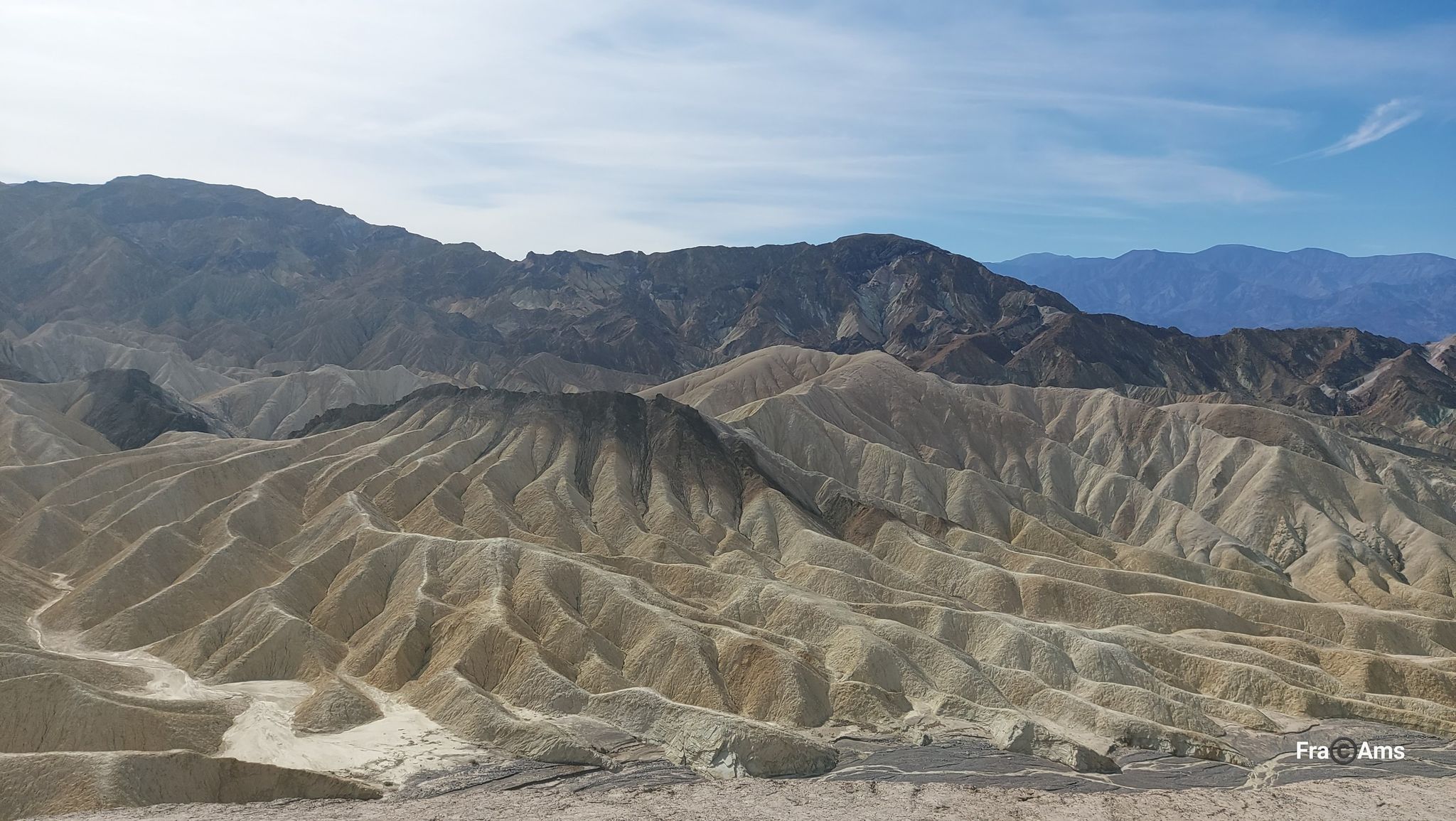 Panoramic view of undulating desert hills and distant mountains under a partly cloudy sky. - Golden Canyon, Gower Gulch and Badlands Loop